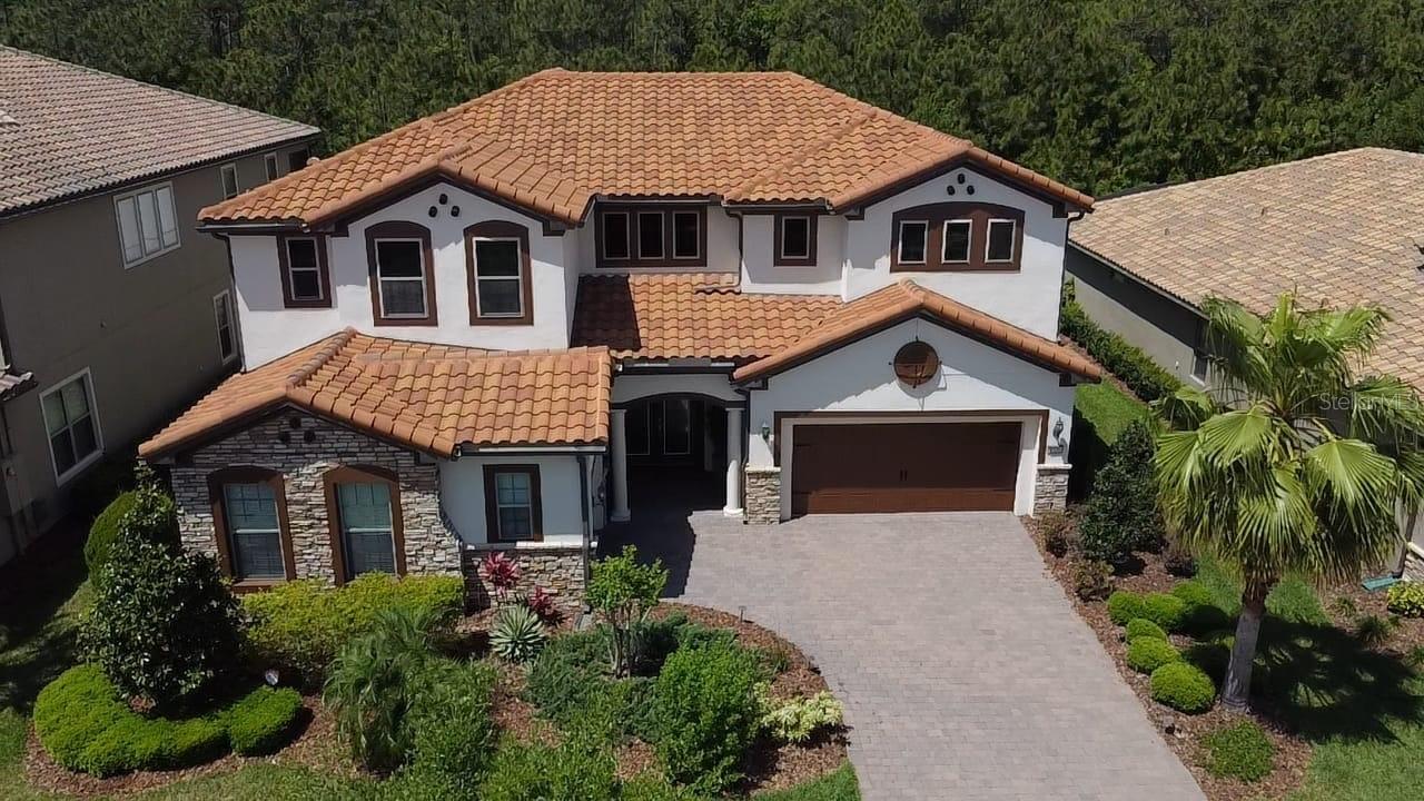 The 8556 Adalina Pl is a stunning, luxurious 4,831 SF living area of a 6,536 SF Total building area 'Portside' model home from builder Pulte Homes, five-bedroom, three full and two half baths, two-story, located on conservation grounds and with a large wooded area behind the house. This house is in Enclave at Village Walk, a gated community in Lake Nona, with an oversized master bedroom suite, a formal dining room, a home office, as well as an open kitchen/gathering room on the first floor. The gourmet kitchen features a massive center island, high-end stainless-steel appliances such as the double wall oven and natural gas cooktop, a KitchenAid oversized stainless steel French door refrigerator, a butler’s pantry, a walk-in storage pantry, an island, and café seating. The home’s gathering room features a wall of glass sliders that completely open the home to the outdoor living space with panoramic views of the large lanai covered and custom-built heated saltwater pool, spa fountain, and private conservation area. Upstairs are four guest bedrooms, two full baths – perfect for modern family living and entertaining relatives and friends.  The enclave residents through the HOA enjoy free amenities such as a gated community, complete lawn care, internet, cable, security, and a sprinkler system. In addition, the Village Walk Community offers the Enclave residents a beautiful Lap Pool, Resort Style Pool, 24-hour State of the Art Fitness Center, lighted trails, scenic bridges and canals, salon, Tennis Pavilion, several lighted tennis courts, basketball courts, lakeside gazebo, gas station, coffee shop and deli market, post office, game room, and multipurpose room big enough for family gatherings, with a 24-hour guard.  Residents are a short drive away from Medical City, educational institutions, Orlando International Airport, KPMG Lake House, Disney, Universal, SeaWorld, USTA's state-of-the-art 100-court tennis facilities, and new Orlando City Soccer training facilities. This house is zoned for ‘A’ rated schools such as Village Park Elementary, Lake Nona Middle & High School, and is convenient.  If the new owner desires the present tenant to continue with the present $5,900/month rent through the current lease ending on March 20, 2026, or otherwise vacates when the sale occurs. Even if the new owner desires to keep the tenant beyond the present lease expiry in March 2026, then the tenant wishes to continue, the new owner and the tenant can discuss.  The Brown painting (garage doors, windows, and trim) warranty is transferable to the new owner, and the company number will be provided to answer any questions.  The nice, long Living Room and Eat-In Kitchen drapes/curtains were preserved by the tenant in the garage, and those will be available to the new owner at no cost, if desired. Along with the appliances Washer and Dryer also convey.