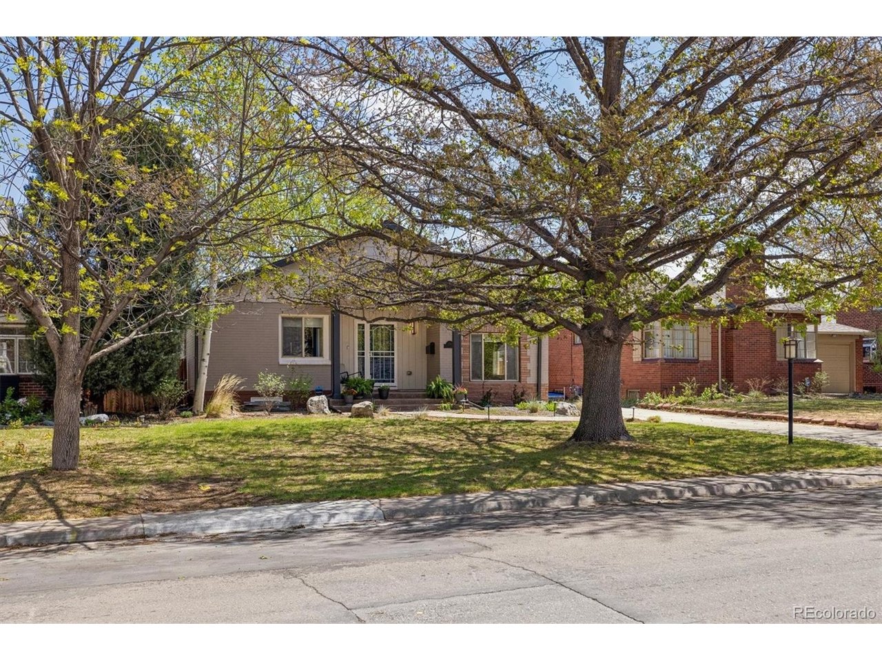 Set on a serene block in the great Mayfair neighborhood, a very special home awaits you. The foyer, graced by the custom glass front door, has a built-in bench w/ attractive storage cubby and a large coat closet. The living room has a warm, calming feel with two Sola tubes for added light. Step down to the truly awesome gathering kitchen & dining room with its 10' wood beamed ceiling, abundant self-closing, maple cabinetry including the top set with glass fronts, a custom wood hood, stainless farm sink and tasteful tile work, this combination of rooms is a highlight of the home.  The two main floor bedrooms are separated by a renovated bathroom with walk-in shower and sharp walnut cabinetry. Primary closet is 7 feet long. The lower garden level has a comfortable family room, large laundry room, a 3rd bedroom with an egress window and renovated full bathroom with defogging mirror. The backyard has a wonderful, covered patio dining area and extended stone patio area for additional outdoor seating. Private, nicely landscaped, fenced yard, low voltage lighting and an electric driveway gate. The two-car garage has stairs leading an open storage area. The roof has Grade 4/Level 4, hail resistant roof shingles and gutters that were installed in 2026. This central location is close to Cherry Creek, Downtown and has good highway access to the Airport.
