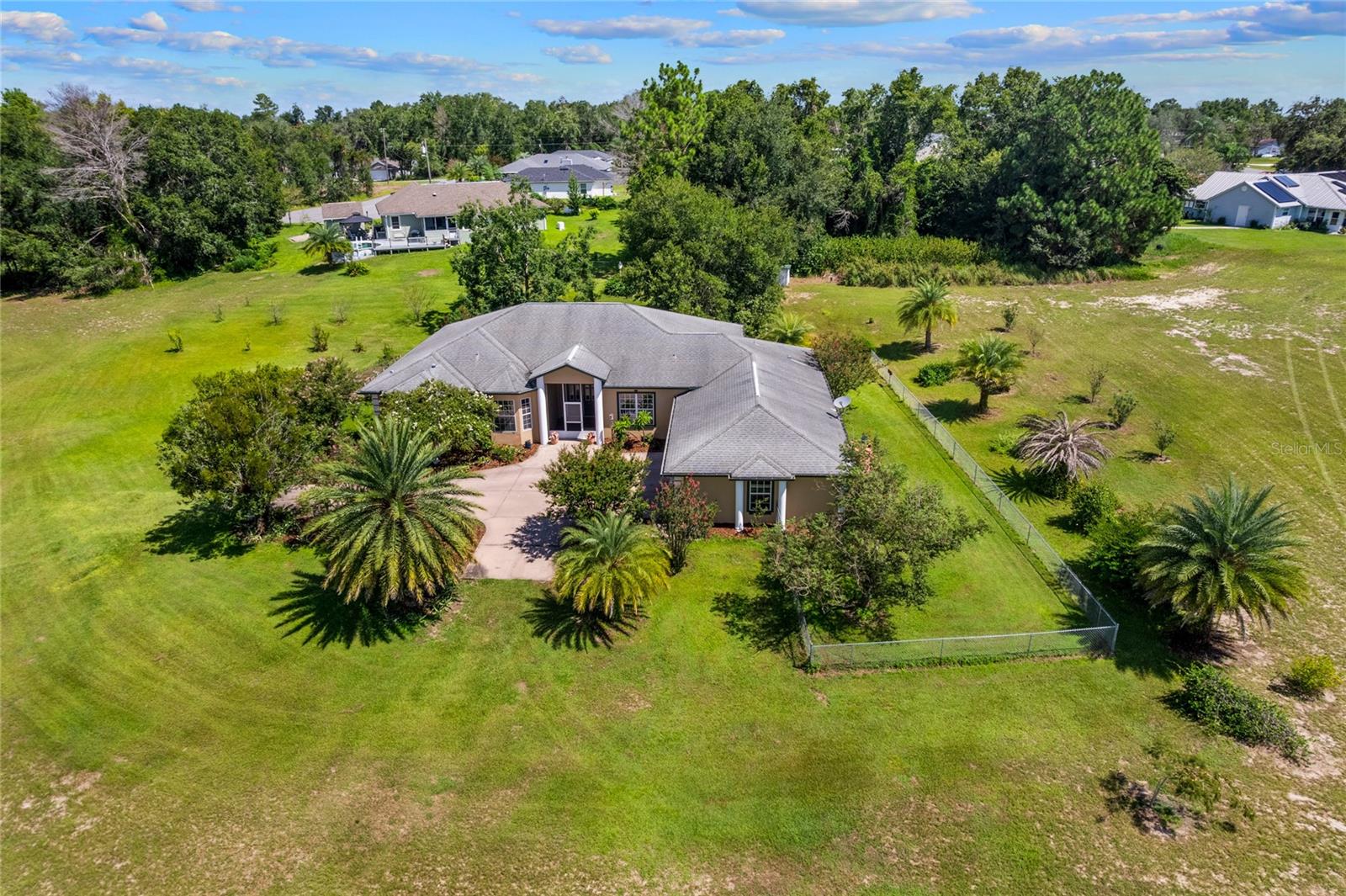 PRICE REDUCED UNDER APPRAISED VALUE!!! Welcome to your piece of paradise including an 8-acre property with cement block construction, stucco exterior, and fresh paint inside and out. Enjoy the spacious 3,020 sq. ft. finished living space with 4 bedrooms, 3 bathrooms in this custom-built home with vaulted ceilings, the master suite with large walk-in closet, en suite bathroom featuring jetted tub and roman-style walk-in shower with two shower heads is sure to please. On the other side of the split floorplan, you will find 2 bedrooms with shared Jack & Jill bathroom and pocket doors (standard closets). Additional large bedroom with standard closet and full bathroom across the hall (also serves guests), formal dining room off the living room. This is a pet friendly layout with dog door from kitchen to screened lanai and from lanai to covered patio with exterior ceiling fan. A large 3-car garage (825 sq. ft.) with attached laundry room awaits your vehicles and/or toys with plenty of additional storage. 
Outdoor features include screened-in back lanai and screened-in front vestibule large fenced yard encompassing rear and side of home (approx. 1 acre irrigated with six zones), water fountain in backyard with continuous fresh water supply and electricity, seven mature palm trees and mature gardenias, organic blueberry hedge (approx. 120 sq. ft.), fruit trees: 3 young Plouhari trees (plum-cherry hybrid, fruiting in early spring), 2 young apple trees (not yet fruiting).
Previously operated as a plant nursery - extensive underground irrigation remains, with four water spigot locations, 2,400 sq. ft. metal building with concrete floor, electric, and plumbing (ideal as workshop, office, or storage), large chicken coop (16' x 8' x 8') with fenced run, automatic sunrise/sunset door, and water supply. - Mature live oaks, cleared and maintained grass throughout and a private driveway to property make this a MUST see!
ADDITIONAL OPTIONS
- Adjacent 0.37-acre lot available for purchase, providing additional residential access point for improved ingress/egress
- Option to purchase farm equipment, including:
- Yanmar diesel 40-horsepower tractor, finish mower deck, one plow, disc for disking the field, rake for raking the field