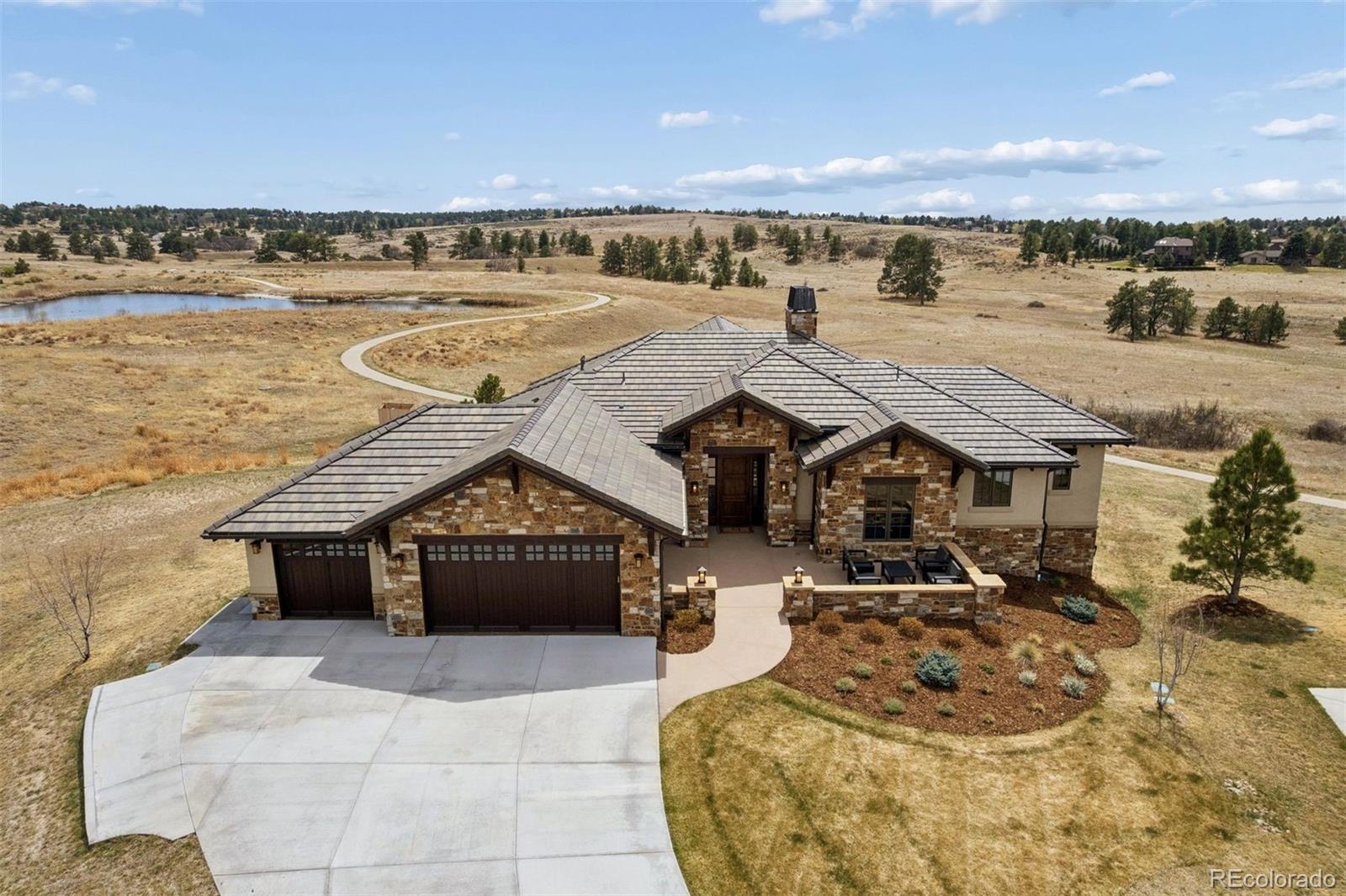 Exceptional custom built home in the Betts Lake neighborhood of the prestigious Colorado Golf Club is mindfully positioned on a .67 acre lot offering privacy and breathtaking views. From the time you enter through the handsome knotty alder front door you immediately sense the Colorado style which embodies this home.  The great room welcomes you with extraordinary views of the protected land conservancy rich with wildlife behind the house through the wall of glass.  The glass wall system fully opens to the outdoor living room which features a tongue and groove vaulted ceiling and an eight foot linear gas fire pit table which is a perfect spot to soak up the spectacular sunsets to the west and the impressive sunrises to the east. The main level has two bedrooms and bathrooms.  The primary bedroom is generously sized and has a large custom closet with center island and storage bench.  The second bedroom is currently used as a study with a built-in a bookcase and has access to a 3/4 bathroom with a zero entry shower.  The terrace level provides three additional bedrooms all with large walk-in closets and two bathrooms, one ensuite, and the other with two vanities and an oversized shower.  The large rec room features an inviting bar with quartzite countertops and a wine refrigerator. An old-world wine cellar adjoins the bar which adds both utility and interest with two dramatic glass walls to showcase your wine.  Experience the pinnacle of Colorado living!