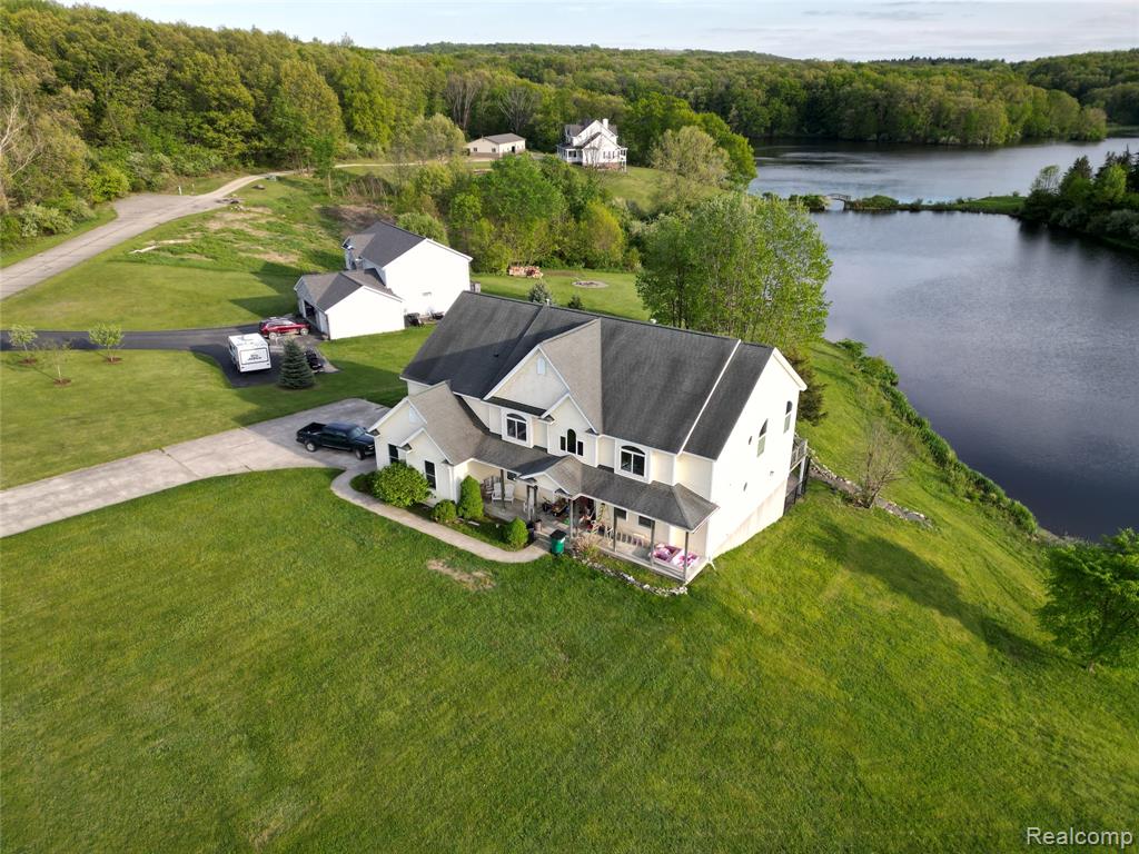 A spacious home with Breathtaking Views of Tody Lake, featuring over 4600sf, in a private community IN the Goodrich School District and on an acre with 150 ft of lake frontage. This community is surrounded by over 2,000 acres of the Ortonville Recreation Area according to the Lake Orion Review.  Look beyond and you'll notice the exceptional construction that the builders used to build this home.  This home offers walk in closets and a bathroom in every bedroom.  A laundry room with a storage island and 1/2 bath with a view too!  Not to mention the GREAT ROOM with a wet bar, fireplace(on each floor), 18ft ceiling, and a fantastic view of Tody Lake.  An amazing home for entertaining!  The kitchen boasts a superior Italian porcelain tile, and talk about cupboards and storage, this kitchen has it all:  Multiple ovens, cooktops, and pantry AND a Butler's Pantry with 2 convection ovens. The home needs some finishing touches, needs new decks,  and a geothermal recharge, but the price reflects what this home needs.  It also has a walk out basement. Just outside the walkout basement is an amazing inground pool that is also a jacuzzi!   Look beyond the boxes/bags and see the glory of this home.  Note:  Goodrich City Center is less than 5 miles. More photographs coming!