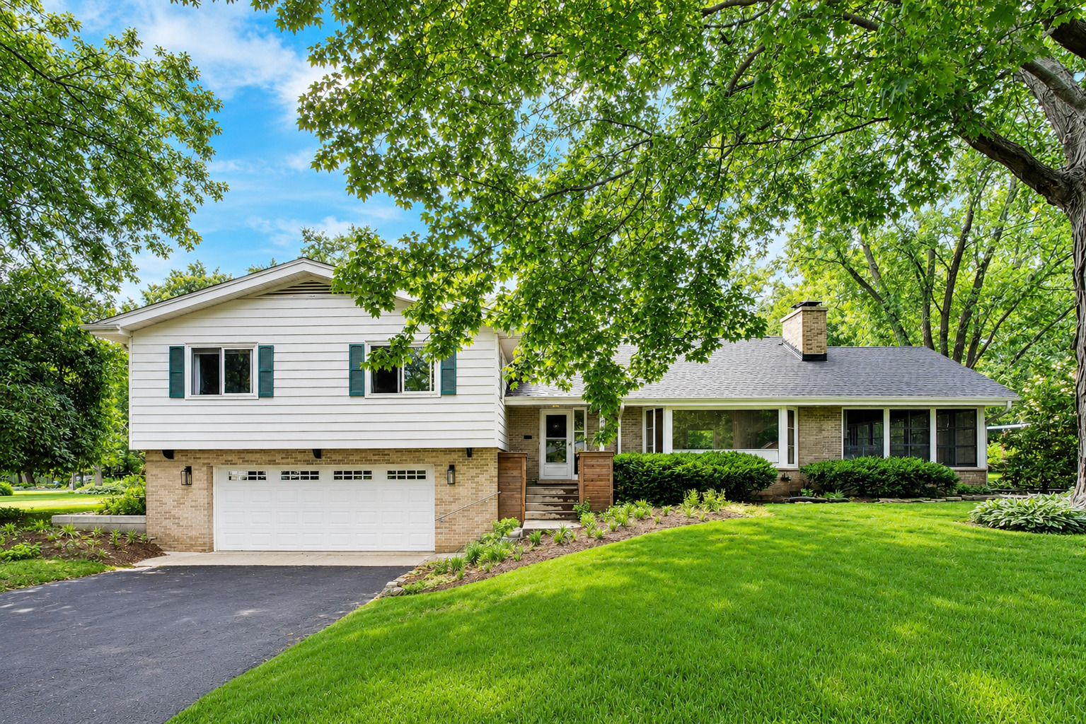 Fantastic opportunity to own a beautifully updated home in highly sought-after Plum Grove Estates, known for its quiet tree-lined streets, oversized lots, and top-rated schools. Thoughtfully renovated, this spacious split-level with Mid-Century Modern character and a sub-basement blends timeless architecture with today's modern conveniences. The stunning gourmet kitchen serves as the heart of the home, featuring custom white shaker cabinetry, premium appliances, a new skylight, and direct access to a newly constructed deck for seamless indoor-outdoor entertaining. The open floor plan showcases vaulted ceilings with exposed beams, restored hardwood floors, abundant natural light, and a wood-burning, statement fireplace. The inviting three-season room provides additional living space overlooking the beautifully landscaped backyard. Recent exterior improvements include a new roof, gutters, garage door, concrete entry stairs, retaining wall, and updated landscaping. Upstairs, the expanded primary suite was created by combining two bedrooms, while both full bathrooms have been completely renovated with updated plumbing, electrical, and heated floors. New energy-efficient windows and refinished hardwood flooring complete the second level. The lower level offers a family room, a dedicated office, a renovated powder room, luxury vinyl flooring, and wet bar. Additional updates include an upgraded electrical panel, well improvements, high-efficiency water heater, sump pump, and a heated garage featuring epoxy floors, built-in cabinetry, foam insulation, and an EV charging station. Ideally located near parks, shopping, dining, expressways, and award-winning schools, this home offers the perfect combination of style, function, and location.