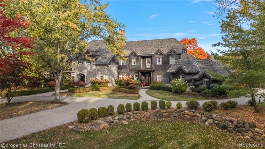 Experience timeless elegance and modern luxury on nearly four acres of pristine grounds.This extraordinary estate evokes the grace and character of a grand European manor, blending old-world craftsmanship with refined comfort. Upon entry, you’re greeted by soaring ceilings and a stunning interplay of rich wood beams and natural stone, setting the tone for the home’s sophisticated design. The layout seamlessly balances formal and casual living, with a sunlit two-story great room featuring expansive windows that frame breathtaking views of the property and a striking two-sided stone fireplace shared with the gracious dining room. Two primary suites are conveniently located on the main floor, each offering a spa-like ensuite bath, dressing room, and dry sauna—creating the ultimate retreat. The chef’s kitchen is a true centerpiece, boasting dual islands, premium appliances, and a spacious breakfast area that opens to the inviting family room accented by the same magnificent beams and stonework. Enjoy the changing seasons in the charming three-season room or ascend one of two elegant staircases to discover four additional bedrooms and three full baths upstairs, providing ample space for family and guests. Outside, the property transforms into a private resort with an in-ground pool, pool house with full bath, sports court, and oversized gas fire pit—all surrounded by beautifully landscaped grounds. Residents also enjoy exclusive privileges at Upper Straits Lake. A rare offering where timeless architecture meets modern comfort—this is estate living at its finest.