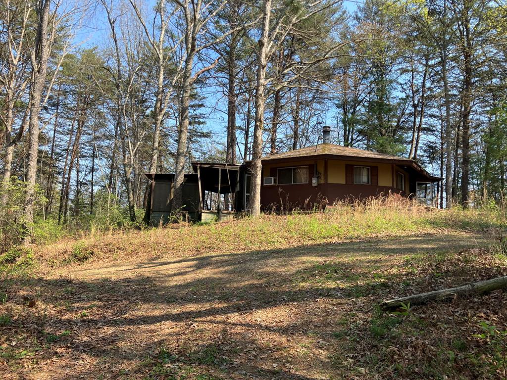 Mountain Getaway Fixer — 2 bed / 1 bath on 4.8 acres (lots 1,13,15,16,18) of mountain privacy at its finest — a unique round house offering 2 bedrooms and 1 bath on approximately 4.8 acres of serene, wooded land. This rustic getaway features durable concrete floors, a cozy gas-log fireplace as the focal point of the living area, and an open, circular floorplan that invites creative renovation. The property is a true fixer-upper with great potential for a full-time retreat, vacation rental, or private homestead.  Key highlights  2 bedrooms, 1 bathroom Round, one-of-a-kind floorplan Concrete flooring throughout — low maintenance and modern-industrial appeal Gas-log fireplace for easy warmth and ambiance Approximately 4.8  acres providing privacy and mountain views potential Ideal for buyers looking to renovate and customize