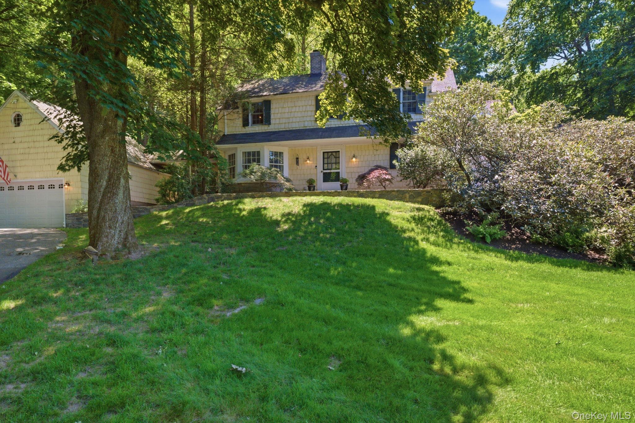Some homes have good bones. This one has great ones in a private setting. Nestled in Chappaqua's beloved Seven Bridges neighborhood, this 1934 Colonial sits on nearly three-quarters of an acre where tree-lined streets and a true sense of community have drawn families for generations. Original hardwood floors, a wood-burning fireplace, crown molding, and a screened porch speak to craftsmanship that simply cannot be replicated. An updated kitchen with granite countertops, wood cabinetry, and a gas range bring real functionality to the floor plan. Main floor offers living room with attached screened in porch, formal dining room, family room / breakfast room, kitchen, huge en-suite bedroom and laundry room. Upstairs holds four more bedrooms, primary ensuite and another full bathroom.  Basement has slop sink with laundry hook up and mechanicals. A 2-car garage with a huge walk-up attic, and two additional attics accessed from inside the home give you the space and storage to match your needs. Bring your vision and make it yours in one of Westchester's most sought-after school districts.