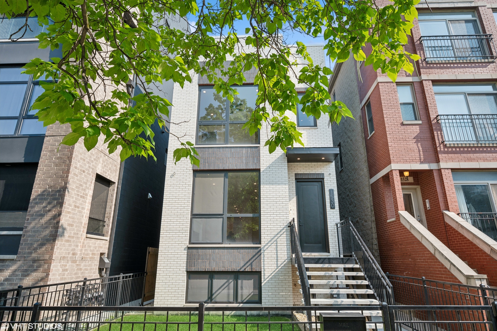 Newly constructed in 2023, this elegant single-family home in West Town seamlessly blends modern luxury with functional design. This 5-bedroom, 4.5-bathroom residence features a full rooftop deck, a garage deck, and a spacious grass front yard and backyard. Lumini windows and 6.5-inch wide-plank hardwood floors enhance the interior's sophistication. The open floor plan showcases a bright, south-facing living and dining area with a quartz-surround fireplace. The gourmet kitchen boasts high-end Thermador appliances, Brizo fixtures, and a large quartz island. Post-construction upgrades include high-end motorized window shades, custom closets, and dual HVAC systems for year-round comfort. The second floor offers three bedrooms, each with en-suite bathrooms, and a convenient side-by-side laundry closet with a countertop. The primary suite features two spacious closets and a spa-like bathroom with an extended double vanity, heated floors, a freestanding soaking tub, and a multi-jet glass shower. The lower level includes two large bedrooms, a recreation room with a den and wet bar, a full bathroom, extra storage, and an additional laundry hookup. The recreation room's den, enclosed by barn doors, provides versatile space for an office, gym, or guest room. Ideal for entertaining, the home features a stunning rooftop deck with skyline views and a backyard perfect for grassy turf or a paved patio. A two-car garage with an additional deck expands outdoor living options. Located in vibrant West Town, steps from West Loop, this home is surrounded by top-tier restaurants and boutique shops.