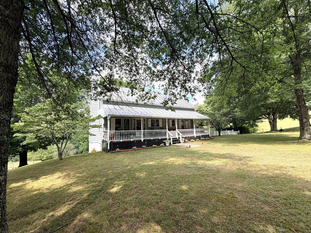 Mini farm with 22 acres in Fancy Gap! Fully fenced pastureland ready for livestock, complemented with creek, barn with equipment shelter, hay barn, 24' x 30' garage/shop with electric & wood heater, conex storage w/equipment shelter, woodshed and double detached carport. Home features: 1613 sq. ft., 3 BR, 2.5 BA, 736 total sq. ft. on front and back porches, 3 heat sources - outside wood heater, propane stove and a heat pump. On the main level you have a spacious living room that walks out to the back porch, updated kitchen with all appliances conveying, dining room with a bay window, primary bedroom and bath. On the upper level there is a loft that overlooks the living room, 2 bedrooms and a half bath. On the lower level you have a full bath, canning area with stove, shelving and sink and a drive under garage. This property has 2 fenced gardens, grape vines, apple and pear trees. Come and feel the cool breeze while sitting on the porch! Located only 1/2 mile from the Blue Ridge Parkway.