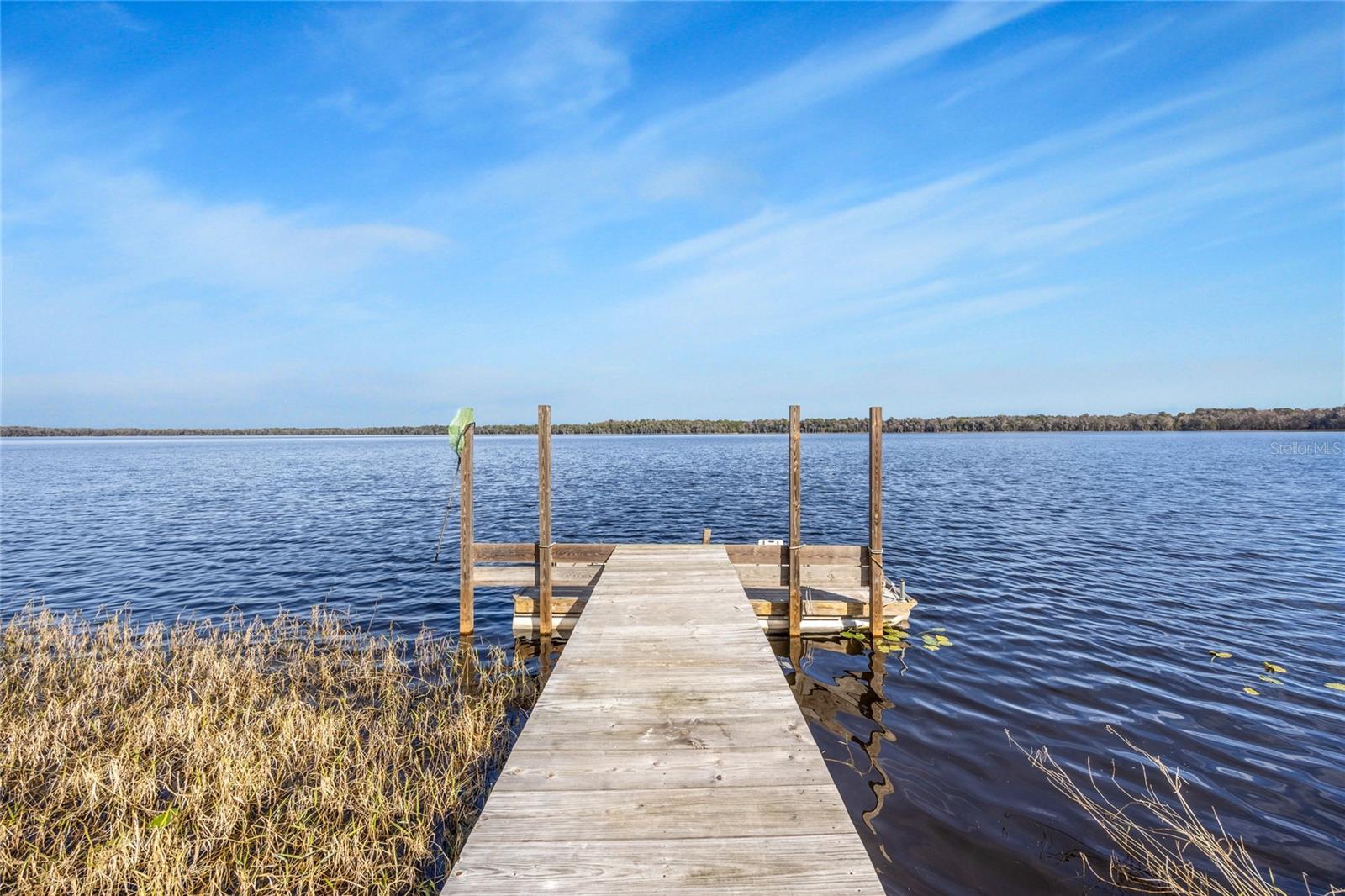 This exceptional Lake Alto estate offers serene waterfront living on one of North Central Florida’s most distinctive natural lakes—a roughly 573-acre waterbody just south of Waldo that helps form the headwaters of the Santa Fe River and is defined by largely undeveloped, conservation-focused shoreline. With expansive lake views, approximately 338 feet of private shoreline, quiet surroundings, and fewer than 30 homes fronting the lake, this rare eight-acre property provides an uncommon sense of privacy, ecological integrity, and long-term stewardship.Thoughtfully arranged across the site are four structures that support true multigenerational living and flexible use. The main residence offers 2,974 square feet of heated and cooled space and includes a large bay suitable for a boat, coach/camper, or future living expansion, while the second lakefront home—1,552 square feet with three bedrooms and two baths—was fully remodeled in 2022, ideal for extended family or guests. A recently updated dock (2022) anchors the lake experience, complemented by a 30'×40' metal workshop and a 12'×20' storage or craft studio, creating a property well suited for family gatherings, creative pursuits, and a legacy-oriented lifestyle rooted in nature.