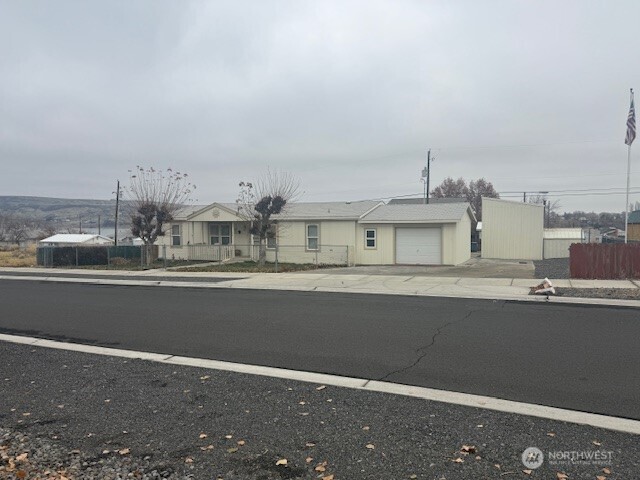 3br, 2ba home on a double lot, attached garage, outbuilding that has been turned into a bonus room w/additional storage.  3 spacious bedrooms. Primary bedroom has private bath and walk in shower.  Open floor plan with living room, dining space and eat in kitchen.  Fun finished extra building that is currently a hang out. Wood Stove, upper loft storage and storage off the side(hidden wall panel) into attached lean to/shed. Covered back deck with partial lake view and fully fenced back yard, low maintenance landscaping.  Front yard is fully fenced with underground sprinklers and covered patio.  An abundance of parking in front and back.  Well priced, ready to move in with great parking and extra space!