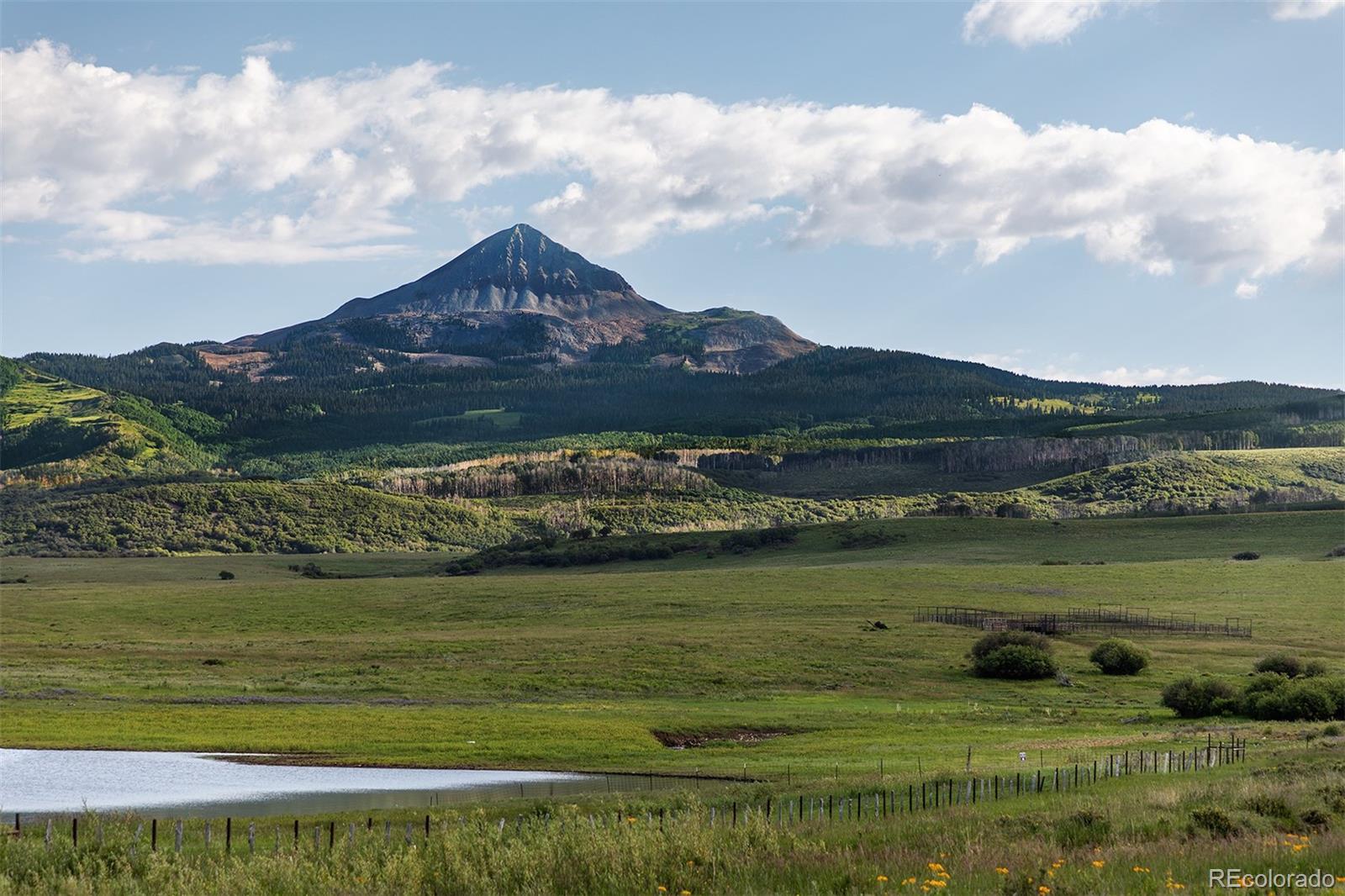 The meadows of Brumley Aspen Waters Ranch rise gently from the shores of Groundhog Reservoir to dense aspen and dark timber forests, enjoying a 3.5-mile boundary with thousands of acres of San Juan National Forest. The assembly of the ranch began in 1900 and has never left the family’s hands. It is rare to find a ranch so raw in the beauty that has remained with one family owner for this length of time.

The abundance of water, massive aspen groves, dark timber, plentiful elk herds, quality grazing, and beautiful scenic views make the ranch unique. Numerous ponds dot the land, and at least two creeks cross the ranch. Beaver ponds have created a fishery that the next owner can enhance. Groundhog Creek is a year-round stream that feeds into Groundhog Reservoir, a designated Colorado State Wildlife Area.

The ranch backdrop features two iconic Colorado mountains, Lone Cone Peak and Groundhog Mountain, both over 12,000 feet in elevation. The lush grass and numerous watering holes allow the grazing of up to 400 yearlings each summer should the owner decide to do so.

Wildlife is plentiful, and the ranch is well known as an elk calving ground; each spring, hundreds of cow elk make their way down from the forest into the lush meadows of the ranch to birth their offspring. Of course, the bull elk follow in the fall, and the hunting and wildlife viewing is world-class.

A new three-bedroom and loft home is nicely finished and has great views. Located near the house are an older cabin and workshop. The Brumley Aspen Waters Ranch is a special offering looking for its next steward.