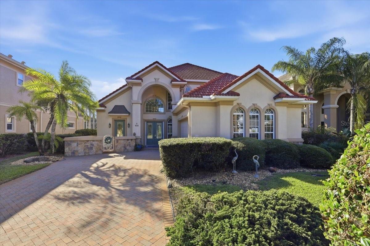 Set beneath mature oak trees with views of Emerald Lake, this custom lakefront home in Palm Coast Plantation offers an inviting blend of comfort and thoughtful design. The residence features three bedrooms, a den or office, three and a half bathrooms, and more than 2,800 square feet of living space. A side-facing 2.5-car garage and welcoming curb appeal greet you on arrival.Inside, soaring ceilings, crown molding, coffered details, and built-in features add character throughout. Marble, stone, and hardwood flooring bring warmth and texture to the home. The spacious first-floor living area centers on a fireplace and flows into the formal dining room and breakfast nook. Large windows bring in natural light, while a three-panel sliding glass door opens to the screened lanai and backyard.The oversized kitchen is designed for everyday use and entertaining, with granite countertops, wood cabinetry, a six-burner gas range, stainless steel appliances, a center island, dry bar, built-in desk, and generous counter space.The main-floor primary suite includes  private access to the lanai. Its en suite bathroom features dual vanities, a separate soaking tub, and a walk-in shower with updated tile. New flooring in the primary bedroom and bathroom adds a fresh touch. Upstairs, a loft and sitting area connect dditional bedrooms, each with its own beautifully updated  full bathrooms. One bedroom opens onto a private terrace with views across Emerald Lake and the backyard.The oversized screened lanai is a focal point of the home, with an inground pool with waterfall, spa, and tranquil lake views. The pool is gas-heated and saltwater-purified, creating a relaxing setting for outdoor enjoyment.Additional features include custom window treatments, surround sound, instant hot water, a security system, and a camera for viewing visitors at the front entrance. Recent improvements include fresh paint in the living room, kitchen, primary suite, and guest room, as well as air-conditioning overflow protection.Palm Coast Plantation residents enjoy a clubhouse, resort-style community pool, fitness center, tennis and pickleball courts, playground, 24-hour guarded entry, and boat and RV storage.