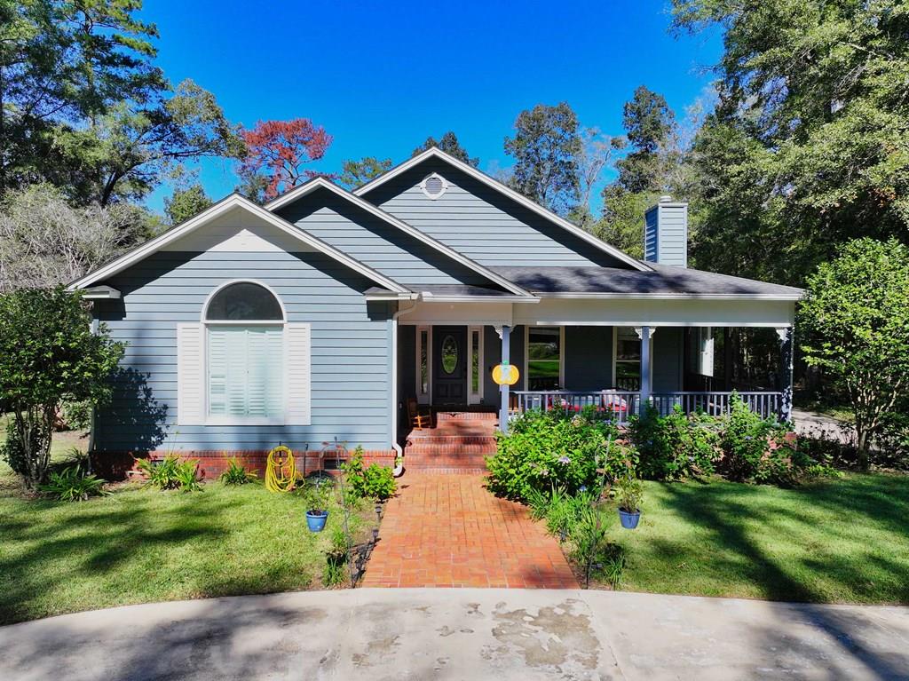 This charming 4 bedroom, 2 bath home offers the perfect blend of rustic warmth and modern comfort. Set on over 2 acres just minutes from Thomasville, the property features an inviting wraparound porch, ideal for relaxing with a morning coffee or rocking away the afternoon overlooking the beautifully landscaped yard. Inside, you'll find a spacious and functional floor plan with thoughtful details throughout. The primary suite includes an attached office or sitting area, providing the perfect space for work or quiet retreat. The family room showcases a cozy fireplace with gas logs and custom built-ins, while the formal dining room is perfect for gatherings. The kitchen offers an island for casual meals, abundant cabinetry for storage, and a bright breakfast nook overlooking the backyard. Upstairs, a finished bonus room and a huge walk-in attic provide additional living and storage space. Step outside to your private oasis—complete with a beautiful gunite pool featuring a waterfall and swim-outs. Additional highlights include a triple carport, workshop/storage building, 9-zone sprinkler system, and security system. Enjoy peaceful country living with the convenience of being just minutes from town!