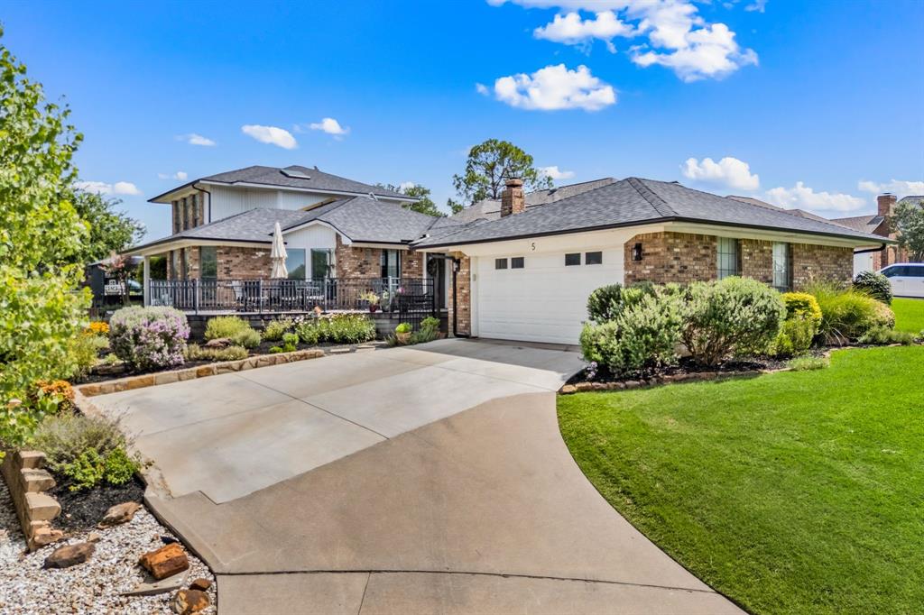 Calling all golfers!......or anyone craving that easy-breezy golf cart lifestyle- this is the one you’ve been waiting for! Nestled in one of the most coveted pockets of Trophy Club and served by exemplary Northwest ISD schools, homes in this charming cul-de-sac rarely hit the market—it’s been years since one has sold. With no HOA, you’ll still enjoy all the pride and appeal of a well-kept, close-knit community. Start your day with coffee on the wraparound front-to-side porch, taking in peaceful pond views or watching golfers cruise by. This community offers rare privacy with one-way-in, one-way-out access and the home with four convenient entry points, ideal for entertaining. The fully landscaped front and side yards are bordered by a walking path with pavers, adding both beauty and function.  Inside, you’ll find three bedrooms, two and a half baths, two living areas, and a dining area. The open concept kitchen is a true highlight, featuring granite counters, all stainless steel appliances, a wine fridge, and a walk-in pantry- perfect for hosting or enjoying a quiet night in. The entire downstairs features hard-surface flooring, with fresh carpet just installed upstairs this July. The private primary suite is tucked at the back of the home and showcases serene golf course views of the 18th hole, private patio access, and a fully remodeled bath completed in 2023. Sitting on a almost quarter-acre lot, the property includes an oversized detached garage connected by a covered breezeway, plus shared guest parking out front. Additional notable updates include a new roof (2023), new HVAC (2022), and upgraded driveway, retaining wall, and French drains (2023). This isn’t just a home-it’s a lifestyle. Come see what makes this tucked-away Trophy Club gem so special!