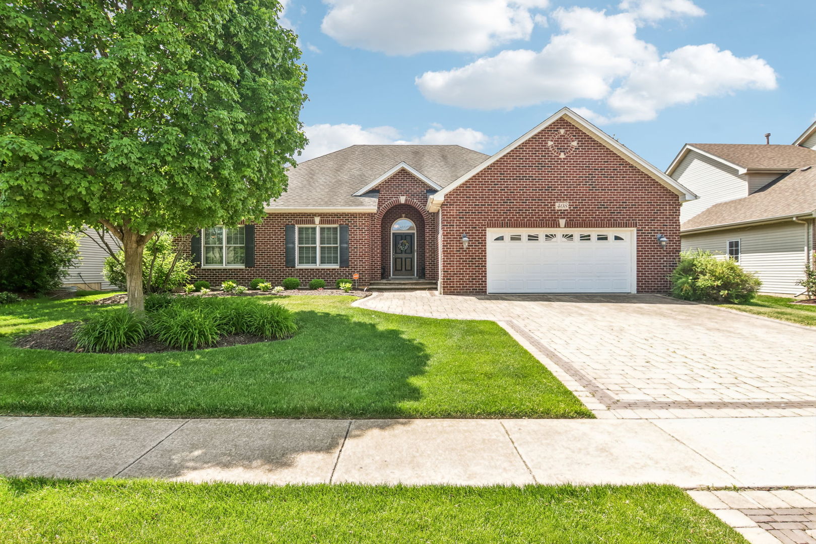 Welcome to 408 Sudbury Circle, a full brick ranch in Oswego's Deerpath Creek neighborhood. Volume ceilings and hardwood floors give the main living spaces an open, inviting feel, while the fireplace creates a natural place to gather. The spacious kitchen features beautiful cabinetry, granite countertops, stainless steel appliances, and plenty of room for everyday meals and entertaining, with easy access to the paver patio for outdoor time. A full basement adds substantial storage and possibilities for future living space. Beautiful Paver Driveway!! Enjoy Deerpath Creek's established setting, with Prairie Point Community Park nearby, offering walking paths, playgrounds, and sports fields.