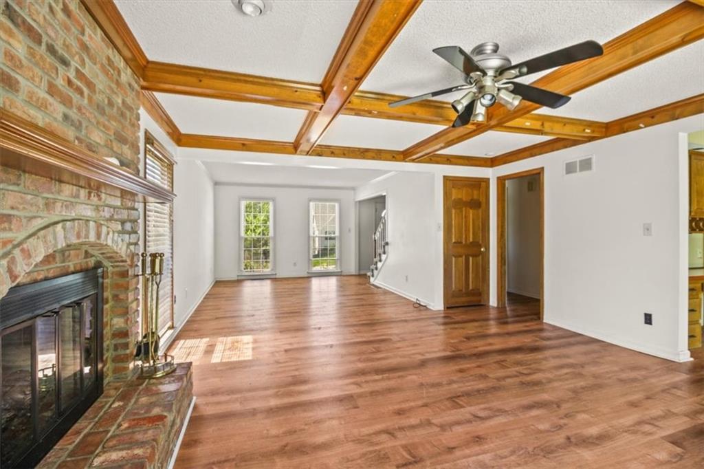 Classic two-story brick-front home with great curb appeal and spacious living areas throughout! Step inside to find warm wood-look flooring, a large living room with a brick fireplace, decorative ceiling beams, and plenty of natural light. The kitchen offers abundant cabinet storage, stainless steel appliances, an island, pantry-style built-ins, and a functional layout with room to gather. Multiple living spaces provide flexibility for entertaining, relaxing, or creating a home office/playroom setup. Upstairs, the bedrooms offer generous space, including a vaulted-ceiling primary bedroom. The bathroom features a double vanity, freestanding soaking tub, and separate tiled shower. The finished lower level adds even more usable living space, perfect for a rec room, media room, gym, or hobby area. Outside, enjoy the mature neighborhood setting, two-car garage, inviting front entry and full fenced back yard!
