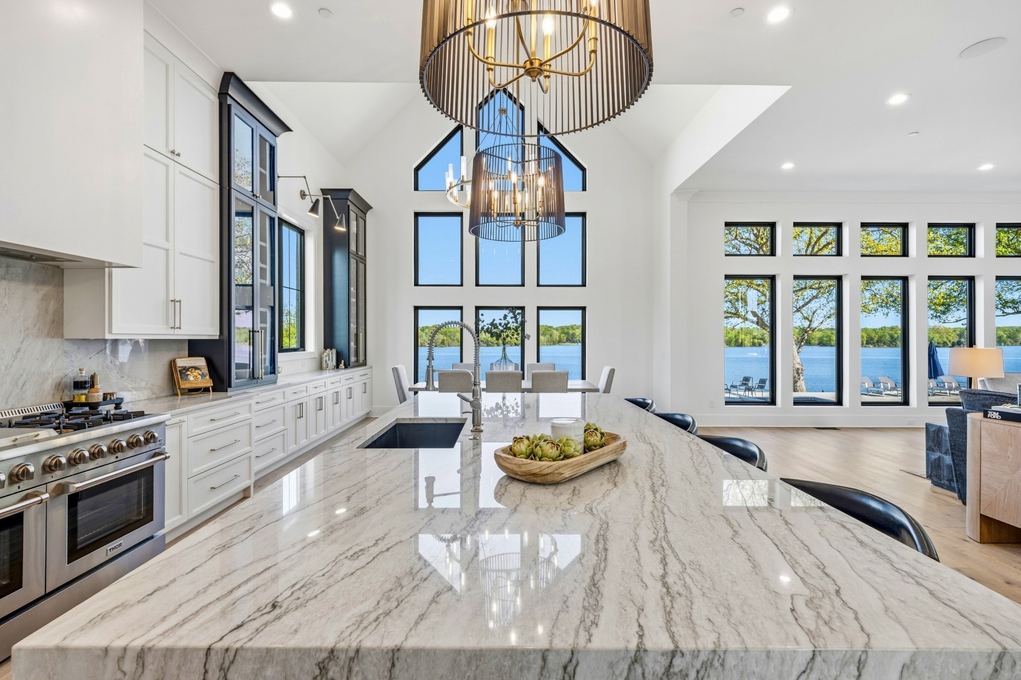 Welcome to 107 Bluegrass Point in coveted Bluegrass Estates! NEW BUILD in 2024 with 8,295 sq ft, 4 large bedrooms (flex space being used as a 5th bedroom) all with en suite full bathrooms & walk-in closets, 5 garage spaces. 12 ft ceilings w 8 inch white oak hardwood throughout the main areas of this turn-key home. Expansive Andersen low-e windows throughout w 70% tint keep the home private & comfortable year round. At the heart of this home is a modern & comfortable chef's kitchen: a full Frigidaire freezer/refrigerator, Thor 48' gas range/oven/pot filler & Thor warming drawer, Zline convection microwave,10 ft quartzite island & countertops, instant hot water, quartzite backsplash, a lovely Butler's pantry with a SS Samsung refrigerator, appliance garage, coffee area w direct water line to the coffee maker, additional granite sink. This home's indoor/outdoor lighting system, security system (with crystal clear 24 hr recording), garages, water features, shades all fully automated. Complete home indoor/outdoor speaker system is fully automated. The Hayward pool & jacuzzi is saltwater & heated, has a large tanning ledge (great for littles), all unobstructed views of OHL. Main level Primary Suite, with exquisite Primary Bath, shower or soak in the free-standing tub with perfect views of OHL. Downstairs office has granite, Urbane Bronze color drenched & a view of OHL. Steel floating stairs lead to a large loft area with 4 more large bedrooms, all with en suite bathrooms & walk-in closets (2 private w lake views/2 Jack-n-Jill). This home is spacious enough to host large events or easily be a multi-generational home. Upstairs has a theatre room, a golf simulator/poker room (full size SS Samsung refrigerator & mini-bar) and a massive Bonus Room. Custom cabinetry throughout the home. Instant hot water throughout the home. Main level sprinkler system & Generac Generator are in place. NO HOA! This lot is grandfathered in to use the lake water for the pond & yard irrigation.