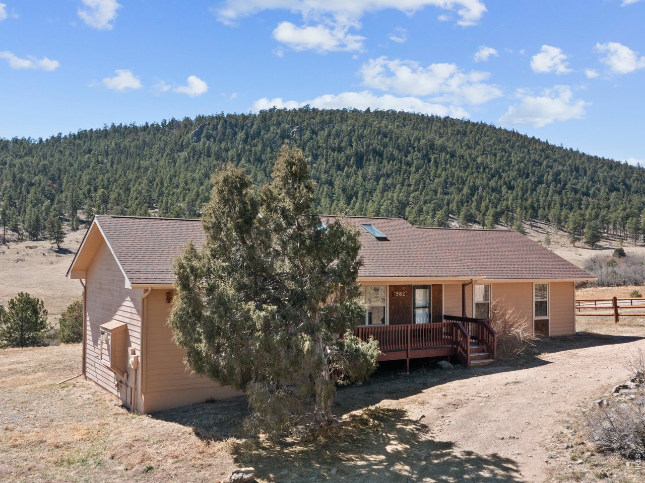 Embrace Colorado mountain living in this spacious ranch-style home on 1 acre just outside Estes Park, where herds of elk and wildlife grace the nearby meadow near Hermit Park. This inviting single-level residence features a generous living room anchored by a stunning river stone gas fireplace with log mantel and hearth, while vaulted ceilings and skylights flood the dining area with natural light. The eat-in kitchen offers both function and charm, and the large primary bedroom provides a private retreat complete with ensuite bath and walk-in closet. Step onto your deck to witness nature's daily show, from grazing elk to breathtaking mountain vistas. An oversized shed provides ample storage for all your outdoor gear and mountain lifestyle needs. This is Colorado living at its finest-where comfort meets wilderness, all within reach of Rocky Mountain National Park.