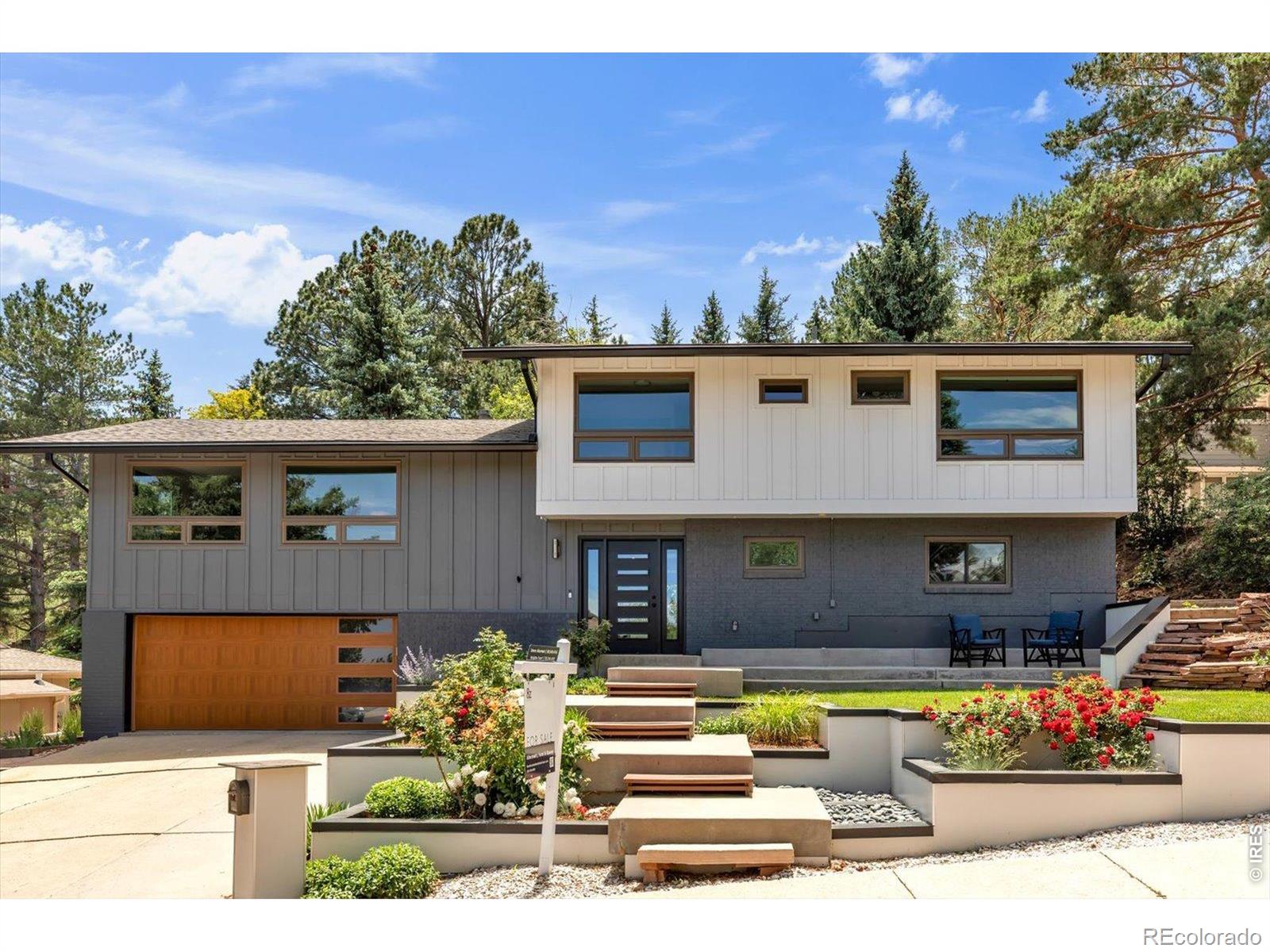 Located in Boulder's coveted Rolling Hills neighborhood, this beautifully updated mid-century modern home occupies a premier position above Viele Lake on a secluded cul-de-sac, showcasing panoramic views from the Flatirons to the sparkling city lights below, with a peekaboo view of Longs Peak. Meticulously maintained and thoughtfully improved with quality materials and craftsmanship throughout, the home is filled with natural light from expansive windows. Hickory floors enhance the open floor plan, where the living, dining, and kitchen areas flow seamlessly together for comfortable everyday living and entertaining. The well-appointed kitchen features a large chef's island, exotic granite countertops, skylights, and views of the peaceful wooded backyard where deer are often seen resting. The dining area opens to a spacious deck, creating a seamless connection to outdoor living. Enjoy mountain, lake, and plains views by day and city lights by night from the comfort of the living room. The primary suite offers a private retreat with a sitting area, walk-in closet, and ensuite bath with radiant floor heat and a steam shower. A comfortable family room with gas fireplace and patio doors opens to the backyard providing the perfect gathering space for entertaining, movie nights, or a hi-fi listening room. A remarkable 23' x 16' home office with a separate entrance off the garage is ideal for visiting clients or colleagues and could also serve as a gym, studio, or workshop. Leave home for work without ever leaving home. The large lot features tiered outdoor living areas, including a generous deck and flagstone patio overlooking the tranquil backyard. Ideally located near trails, parks, Viele Lake, the South Boulder Recreation Center, and within walking distance of Fairview High School. A new Class A roof was just installed. Rarely does a home combine views, privacy, and location so effortlessly in one of South Boulder's most sought-after neighborhoods.