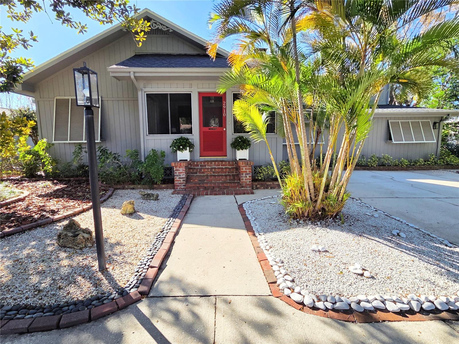 Spacious, historic and dry. Located in a highly desirable non-flood/non-evacuation zone (Zone X), this home features five bedrooms, three full baths plus a convenient poolside half-bath. Boasting nearly 3,000 square feet of versatile living space, it’s situated on a roomy one-and-a-half lots in a quiet, tree-lined residential area just two blocks north of Historic Kenwood. Originally built in 1932 and thoughtfully expanded, this charming home features a large chef’s kitchen, full dining room, foyer, main living room, additional entertainment room, library with custom built-in shelving, screened-in front porch, mudroom and two working wood-burning fireplaces—one in the living room and one in the library. The primary suite on the second floor offers generous space and an en suite bath with a sunny skylight. Architectural details include crown molding, three skylights and French doors that open to the library, entertainment room and expansive backyard.The front yard features low-maintenance, low-water xeriscaping. The private backyard features a large kidney-shaped swimming pool (big enough for laps or pool volleyball) and a six-foot-high brick privacy wall surrounding the entire yard. A separate concrete block outbuilding (approximately 238 sq ft) offers flexible use as a pool house, workshop or creative space, with additional roof-covered storage space in the back and side of the building. An off-street parking pad easily accommodates two large vehicles. Storage is abundant with seven closets—including five walk-ins—extensive kitchen cabinetry, laundry room shelving and attic.Recent updates include a newer roof (2021) on both the main house and outbuilding, exterior paint (2023), new electric tank water heater that serves the kitchen and two bathrooms (2025), new electric tankless water heater that serves one bathroom (2025) and a new washer and dryer (2025).With these major updates already done, this home offers an excellent opportunity to personalize the kitchen, baths and interior finishes to suit your taste.Conveniently located, this home is just 15 minutes from beaches and 10 minutes from downtown by car, with quick-and-easy access to Central Avenue dining and shopping, Mazzaro’s Italian Market, Publix, Walmart, Sam’s Club and Aldi.