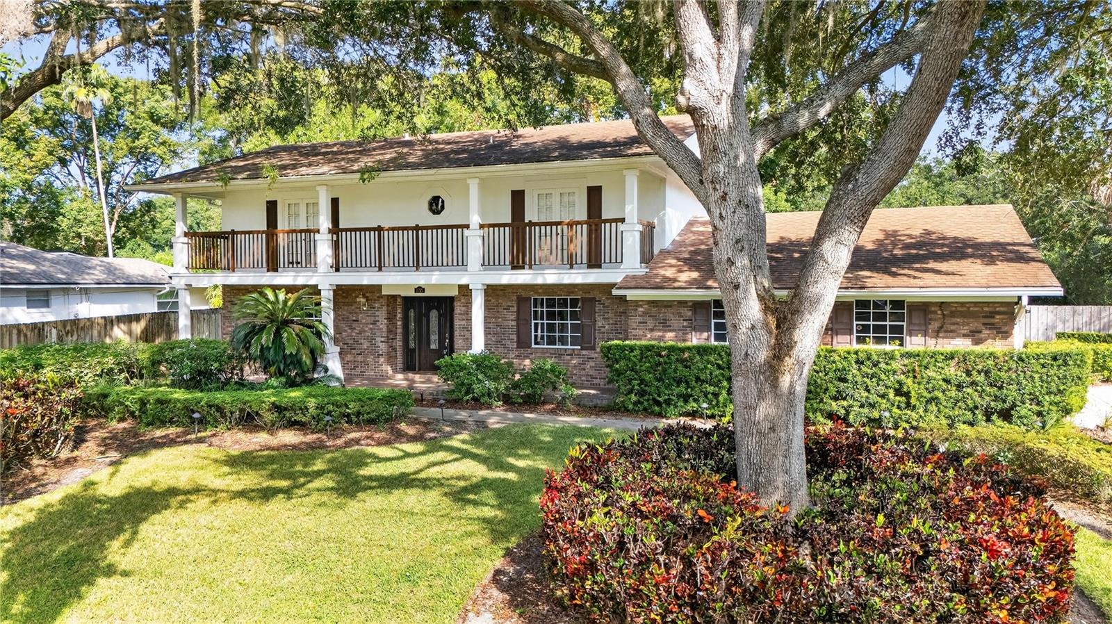 Classic Colonial Brick Home on highly desired E Adama Drive across from Lake Maitland!  4 bedrooms, 4 Baths, 2 fireplaces-one in Primary bedroom!  Full 2nd floor balcony porch with French doors!  Terrific home for entertaining! Formal Dining room across from Formal Living room connected by large foyer!  Family room/Library with built in shelves on both ends with wood burning fireplace!  French door lead to huge covered screened room with summer kitchen.  Sip morning coffee while overlooking inground pool! Relax on your huge front porch while watching the squirrels play in the mature trees serenaded by a variety of musical birds!  Two car garage with long driveway