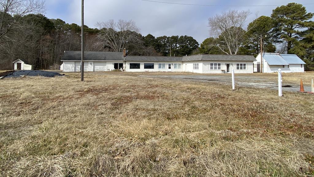 This is a great investment property!  Run your business and live right there.  4+ acres stretches from Lankford Highway to Coal Kiln Rd.  Great exposure for your business. The cleared area is zoned business. This is in the Accomack county Enterprise Zone. The wooded area is zoned agricultural.   Property comes with plenty of storage.  Including the several sheds.  One shed houses the water system.  The rest are for storage.   Large open space as you walk in the door. Was used as a restaurant years ago.  Could be used for several types of small businesses also.   40 year shingles and the flat roof has been resurfaced.  1500 sq ft apt attached has had a remodel started.  Space includes a living room, kitchen , and 3 bedrooms, with a 2 car attached garage with storage above.