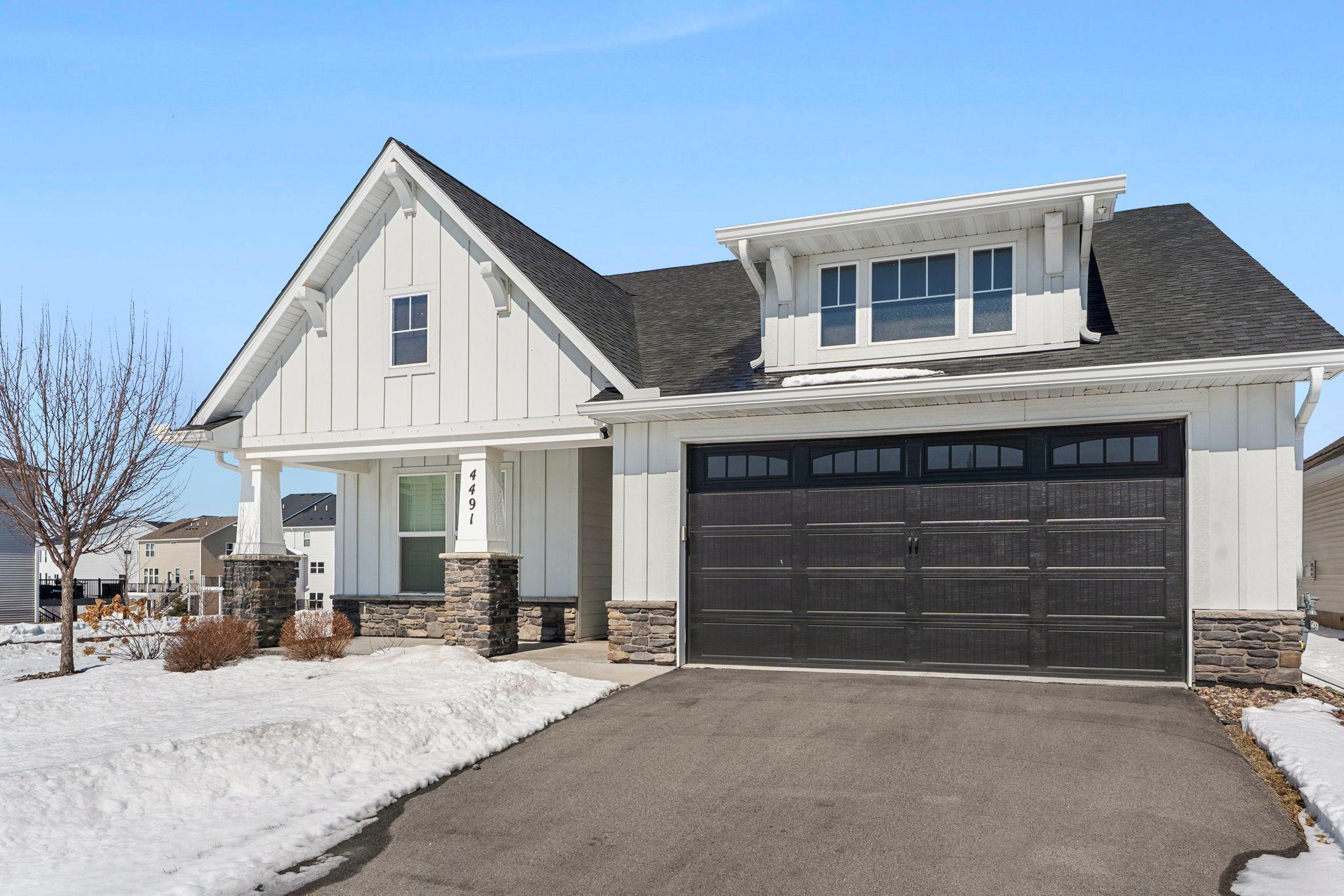 Spacious and beautifully maintained, this 3-bedroom, 2-bathroom home offers effortless single-level living in a peaceful Woodbury neighborhood.Built in 2021, it delivers the benefits of newer construction without the wait, allowing you to move in and enjoy right away.Ideally positioned on a desirable corner lot, the home is just minutes from parks, lakes, scenic trails, Prestwick Golf Club, and East Ridge High School.Inside, a bright open-concept layout with 9-foot ceilings creates an inviting space for both everyday living and entertaining.The kitchen is a standout, featuring stainless steel appliances, a tile backsplash, walk-in pantry, and a large center island with breakfast bar seating, along with premium upgrades like a gas cooktop, pot filler, and wall oven.The living room offers warmth and style with a stone-surround gas fireplace and tray ceiling, nearby a designated dining space and bright sunroom with multiple large windows. Walkout access to a maintenance-free deck, perfect for indoor-outdoor living.The split-bedroom layout offers privacy, with the primary suite as a relaxing retreat. It features statement lighting, walk-in closet, and ensuite with heated floors, walk-in tiled shower, and double vanity.Two additional bedrooms are bright and spacious, conveniently located near a shared full bathroom.Enjoy a functional mudroom and laundry space with Samsung appliances, shelving (2023), and access to 2-car garage.Outside, relax on the inviting front patio or maintenance-free back deck. Recent updates from 2023 include fresh paint throughout and upgraded closet systems.