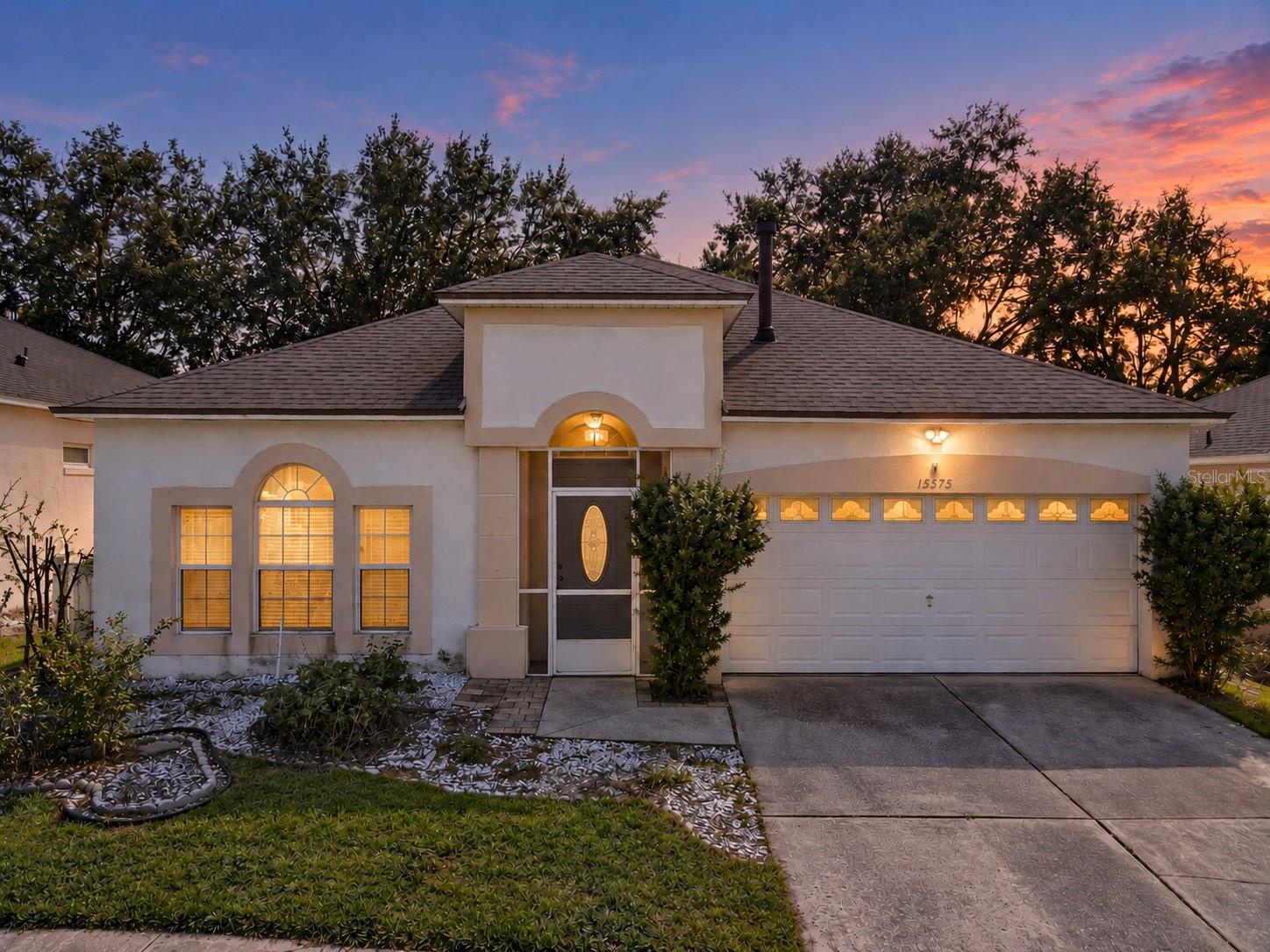 Virtually Staged. Located in the Savannas community in Clermont, this charming 3-bedroom, 2-bath home offers 1,511 square feet of living space with a versatile layout and inviting outdoor spaces. Just inside the entry, a separate living room provides flexibility for a home office, sitting room, or additional gathering space. The family room, kitchen, and dining area are open to one another, creating a comfortable setting for everyday living and entertaining. Luxury vinyl plank flooring extends throughout the main living areas and primary bedroom. The split-bedroom floor plan offers privacy, with the primary suite featuring an en suite bath with a large walk-in shower, while two additional bedrooms and a full bath are located on the opposite side of the home. Major updates include a new roof (2023), A/C (2024), and water heater (2025). Step outside to an extended screened patio overlooking a fenced backyard shaded by mature trees. Beyond the patio, an expansive pavered area with a built-in fire pit offers a wonderful setting for relaxing outdoors, gathering with friends, or spending evenings around the fire. Situated directly across from the community pool, this home also enjoys a convenient Clermont location with easy access to Central Florida's theme parks, shopping, dining, and major roadways. Schedule your private showing and make it yours today! *Aerial photo property lines are an estimate and to be verified by buyer.