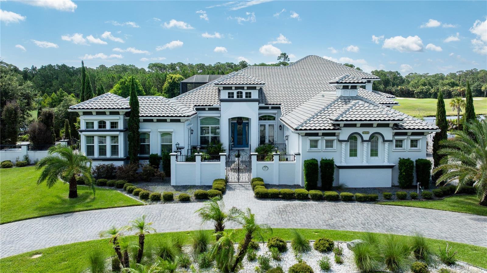 Discover refined Florida living in this beautifully positioned lakefront estate in the sought-after community of Plantation Bay. Ideally situated to capture tranquil water views and scenic golf course vistas, this exceptional residence offers an unparalleled blend of privacy, luxury and resort-inspired living. Designed for elegant entertaining and everyday comfort, the home showcases an impressive collection of amenities, including a private movie theater, temperature-controlled wine cellar and a well-appointed outdoor kitchen ideal for hosting gatherings throughout the year. The outdoor living experience is extraordinary, featuring a screened in-ground pool, relaxing spa, and a custom-crafted water fountain that creates a tranquil setting overlooking the lake and golf course. An expansive English garden extends the property with vibrant landscaping and picturesque pathways, providing a sense of serenity rarely found. Inside, thoughtfully designed living spaces offer sophistication and functionality, while the estate-sized homesite enhances the feeling of exclusivity. Residents enjoy peace of mind of a gated community with 24-hour staffed security and access to an extensive selection of amenities, including championship golf, tennis, pickleball, fitness facilities, dining venues, social clubs, and miles of scenic recreational and biking routes. Whether enjoying a movie night with friends, selecting a favorite vintage from the wine cellar, entertaining poolside from the outdoor kitchen, or simply taking in the stunning lake and golf course views, this remarkable property delivers an exceptional Florida lifestyle. Conveniently near area beaches, shopping, dining, healthcare services and major transportation corridors, this distinguished estate represents a rare opportunity within one of Ormond Beach's premier private communities.