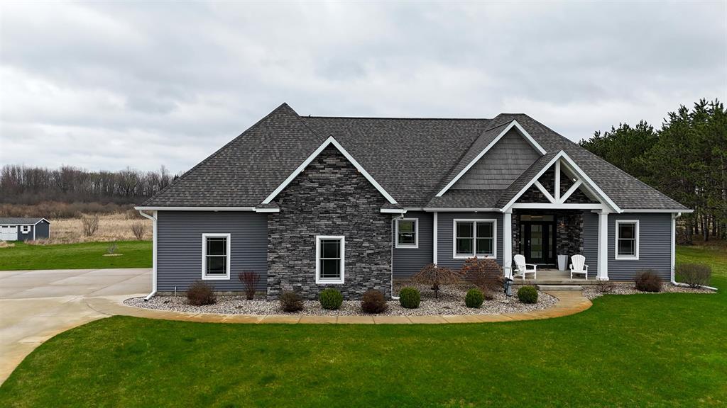 This nearly 5,000 square foot ranch home offers the kind of quality, space, and setting that is hard to find. Built just 9 years ago and situated on over 7 private acres, this one-story home combines impressive craftsmanship with a thoughtful layout designed for both everyday living and entertaining. The main floor features beautiful wood flooring throughout, 3 bedrooms, 2 full baths, and main floor laundry, along with a spacious open-concept living area highlighted by a floor to ceiling stacked stone wall with a fireplace. The soaring ceilings and expansive windows help bring in natural light and peaceful views. The kitchen is a standout with extensive cabinetry, quality finishes, generous counter space, and a large island that opens seamlessly to the dining and living areas. The primary suite offers a spacious retreat with a beautifully finished bath and excellent closet space. Downstairs, the finished lower level adds 2 more bedrooms, a large family room with wet bar, and a separate 26x15 room currently used as a theater room, offering exceptional flexibility for recreation, hobbies, or hosting guests. Outside, the fenced yard provides great usable space while the surrounding acreage creates a private and relaxing setting. Home has RING Doorbell