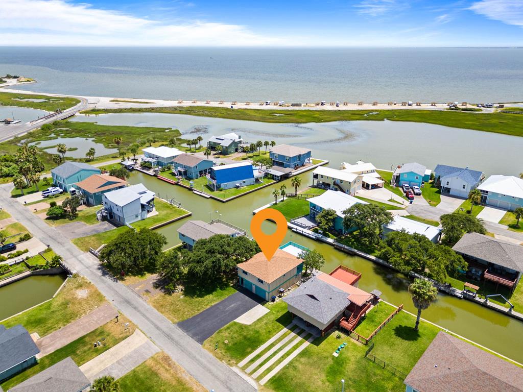 Waterfront living in Rockport!  Nestled in the sought after Neptune Harbor neighborhood, just minutes from all Rockport has to offer, this beautifully furnished 3 bedroom, 2 bathroom home is ready for you to start enjoying the coastal lifestyle you have been dreaming of!   The upper level features an open concept living, dining, and kitchen area designed to capture the amazing views.  The upstairs windows and sliding glass door were installed in 2022, allowing for abundant natural light.  Two spacious bedrooms and a full bathroom complete the upper floor.  Downstairs offers a separate private bedroom and full bath, plus a versatile flex room that's perfect for a craft room, home gym, office, or additional guest space.  Step outside and enjoy the coastal breeze from the oversized upper deck or relax and entertain on the patio downstairs.  A two car garage provides plenty of room for vehicles, fishing gear, and water toys.  Being sold fully furnished, the waterfront retreat is truly move-in ready-whether you are looking for a full time residence or a weekend getaway.  Don't miss your chance to own this charming retreat!  Red lot lines are approximate.