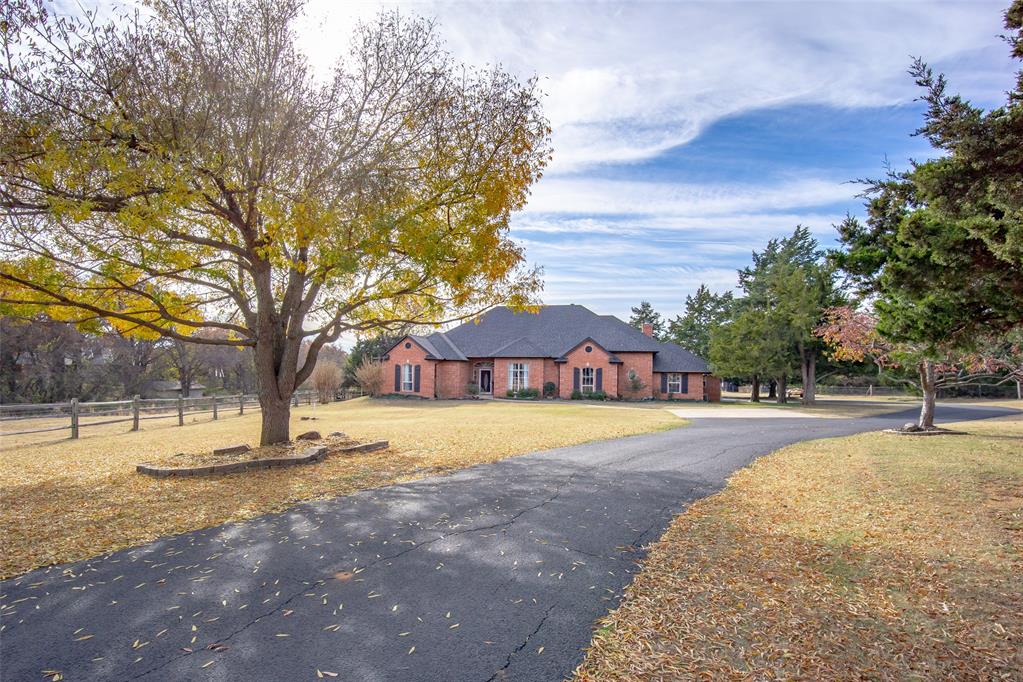 Discover an incredibly rare opportunity to own a true private oasis in Edmond—**5.42 acres** of beautifully manicured, horse-ready land complete with a stocked pond, charming fountain, sprawling barn with an office, and a loafing shed. Fully fenced and tucked away behind a long private drive, this property blends peaceful rural living with in-town convenience. This spacious 4-bedroom, 3.5-bath home is filled with natural light and designed for both comfort and entertaining. Upon entering, you’re greeted by an expansive formal living/game room and an elegant formal dining space. The open-concept kitchen features rich hardwood cabinets, a breakfast bar, and seamless flow into the eat-in dining area and inviting living room—each space capturing serene views of the gorgeous backyard and acreage beyond.The east wing hosts the luxurious primary suite with a well-appointed bath offering a jetted tub, separate shower, and a large walk-in closet with an attached FEMA-rated safe room. A secondary bedroom with its own walk-in closet and ensuite bath completes this side of the home. On the opposite wing, two additional bedrooms share a Jack-and-Jill bath, conveniently located near the laundry room. Step outside to a wooded retreat perfect for exploring nature, fishing, or enjoying a peaceful paddle on the pond. With ample space for horses, hobbies, and outdoor living, this property delivers unmatched tranquility without sacrificing proximity to city amenities. This is your chance to own the ideal blend of rural charm and urban access—an Edmond acreage property like no other.