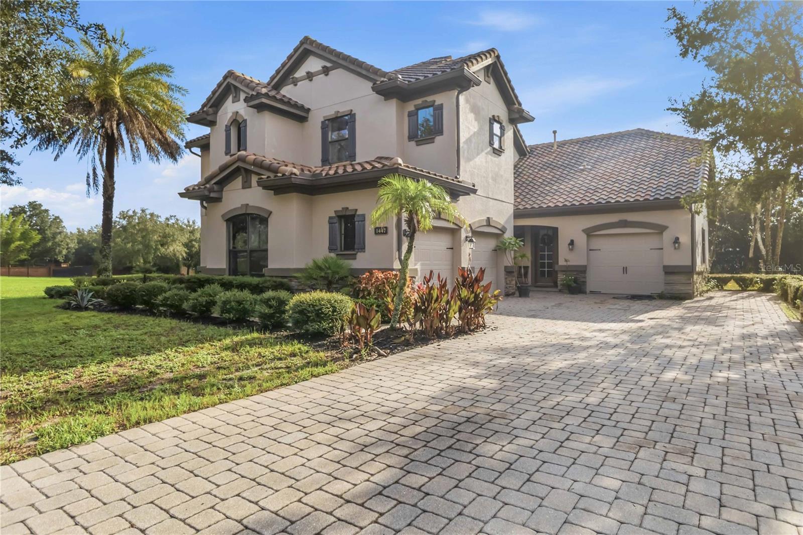 Elegant architectural details, soaring ceilings, and an expansive outdoor setting define this distinctive Longwood residence. Situated on approximately 0.70 acres, this fourbedroom, three-and-a-half-bath home offers approximately 3,487 square feet of living space, complemented by a dedicated office and an upstairs loft. A paver driveway, tile roof, stone-accented entry, and mature landscaping create an inviting arrival. Inside, tray ceilings, crown molding, arched openings, and generous windows bring character and natural light to the formal living and dining areas. The dramatic two-story family room serves as the heart of the home, with an open staircase, upper-level overlook, and sliding glass doors connecting to the covered lanai. Designed for everyday living and entertaining, the kitchen features rich dark cabinetry, stone countertops, a center island, stainless steel appliances, a range hood, and a breakfast bar. An adjoining casual dining area overlooks the backyard, while the nearby office provides a dedicated setting for work or study. The spacious primary suite offers a tray ceiling, direct access to the lanai, and an en-suite bathroom with dual sinks, a seated vanity area, a soaking tub, and a separate glassenclosed shower. Additional bedrooms provide comfortable accommodations, while the upstairs loft adds flexible space for a media lounge, recreation area, or reading retreat. Outdoors, the generous covered lanai creates an inviting setting for alfresco dining and relaxed evenings overlooking the expansive lawn and established greenery. A gated community entrance and proximity to the Seminole Wekiva Trail further enhance the setting. With distinctive interior details, versatile gathering spaces, and abundant outdoor space, this home offers a compelling blend of elegance and everyday comfort. Private entry access to Seminole trail.1 year Home Warranty included