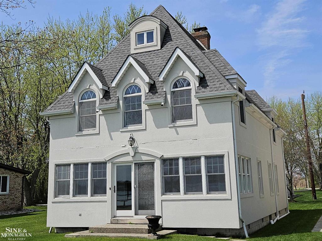 Stunning waterfront views and a lot of curb appeal in this updated home from 1915.  Comfortable living space throughout with beautiful wood flooring and a spectacular stone fireplace makes for a cozy gathering place in winter...or...you may want to spend your day and evening in the sunroom while watching the river traffic and wildlife on the St. Clair River, an international waterway.  Entertain guests in the formal dining room and there is informal breakfast space in the kitchen.  The master bedroom is spacious, the full width of the house and overlooks the river with architecturally unique windows.  Square footage is estimate and does not include the partially finished heated attic with skylights.  Garage has a 1.5 car entrance but is extra deep. The dock provides a panoramic view of the river and Canada!