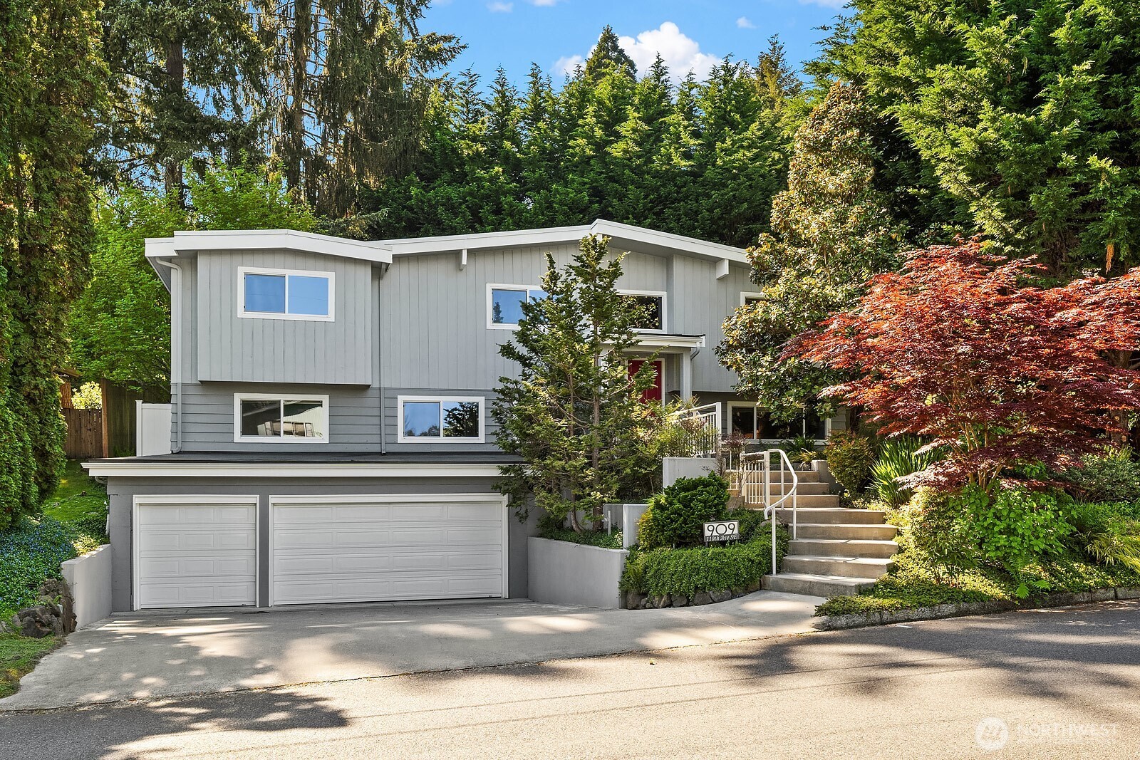 Surrey Downs living at its best: this turnkey 4 bedroom, 2.5 bath home sits just blocks from downtown Bellevue's shops and dining, with architectural character and a functional layout that balance comfort and style. Soaring vaulted ceilings & rich hardwood floors enhance the light-filled living & dining spaces, creating an inviting setting for everyday living & entertaining alike. The chef's kitchen features granite counters, stainless steel appliances, custom cabinetry, & thoughtful storage, flowing effortlessly to the main gathering areas. The spacious main-level primary suite serves as a private retreat & features an ensuite 3/4 bath with an oversized dual head shower & expansive vanity space, plus two walk-in closets & easy access to the backyard. The lower level offers two additional generous bedrooms, a cozy family room with fireplace, & flexible space ideal for guests, work, or play. Added highlights include central A/C, a new heat pump for year-round comfort, two fireplaces, a wine cellar, & an expansive 3-car garage. Step outside to a large patio ideal for entertaining, surrounded by mature landscaping that creates a private, peaceful setting. Enjoy easy access to downtown Bellevue's restaurants, boutiques, & parks, plus quick connections to 405 and I-90, all within the award-winning Bellevue School District.
