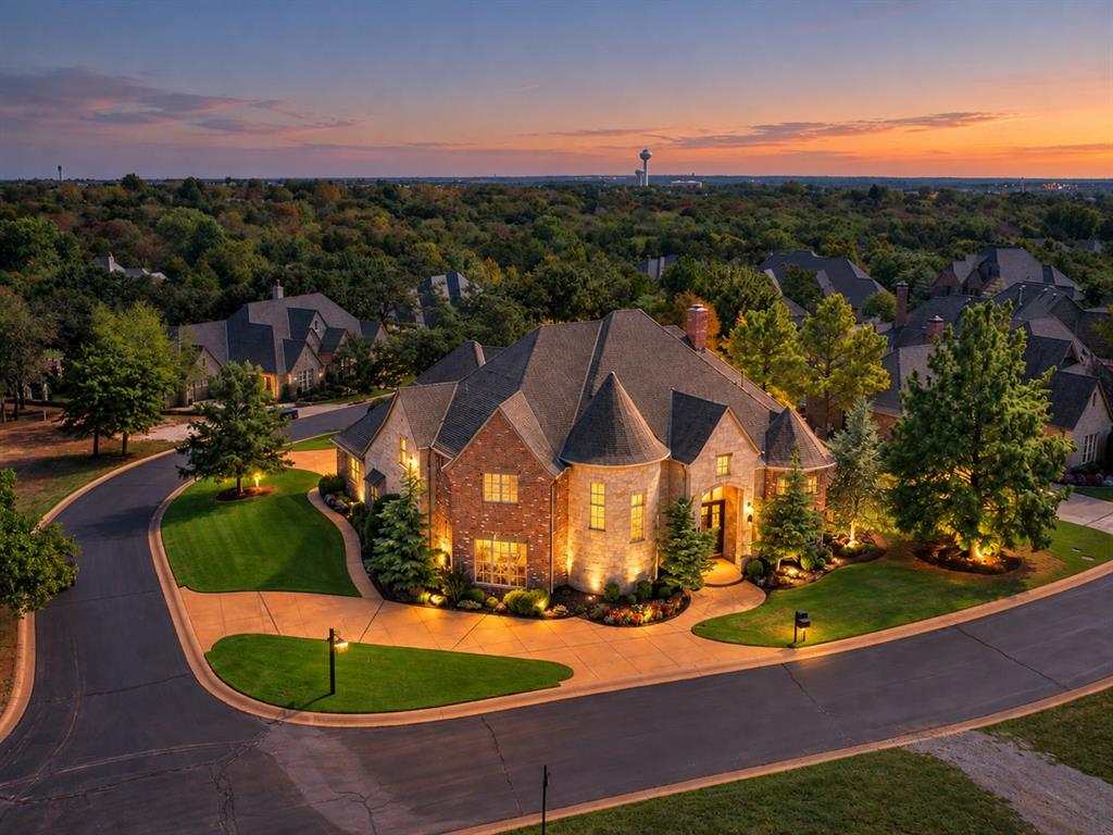 An exceptionally rare opportunity to own in the coveted, gated community of Woody Creek, where towering mature trees, lush surroundings & an active neighborhood social calendar create a setting unlike anywhere else in Edmond. Custom built by Matt Wilson Custom Homes, this impeccably maintained, 5 bedroom, 5.5-bath estate offers over 6,200 SF of exceptional craftsmanship on a wooded corner lot.Grand iron double doors welcome you to soaring ceilings & a sweeping spiral staircase. Rich woodwork, solid wood doors, crown molding & oversized windows define the home. The living room features stunning built-ins & a floor-to-ceiling stone fireplace. A dramatic two-story formal dining room & spacious study with custom built-ins add architectural elegance.Chef’s kitchen features quartz counters, double ovens, 6-burner gas cooktop, commercial-style vent hood, built-in refrigerator, 2 copper sinks, island, breakfast area & oversized pantry. The luxurious primary retreat features private side-yard access (perfect for pets with a pet door!), spa-inspired bath with wet bar perfect for coffee, jetted tub, walk-in shower & extraordinary closet with island. Plus, a safe room! A 2nd downstairs bedroom offers a private ensuite.Designed for entertaining, a 2nd bonus room w/ golf simulator room, wet bar & direct pool access offers endless possibilities, complemented by a full bath for swimmers. The laundry room features abundant cabinetry & a stunning mud bench.Outside, discover a FULLY secluded backyard oasis featuring a resort-style pool, oversized spa with cascading waterfall & expansive patio for dining, lounging & entertaining.Upstairs, a generous bonus room/2nd living opens to an incredible covered balcony overlooking the pool. 3 additional bedrooms with ensuities, while the movie theater features tiered seating, projection screen, built-ins & beverage center.Extraordinary quality, timeless elegance & an exceptional lifestyle behind the gates of Woody Creek.