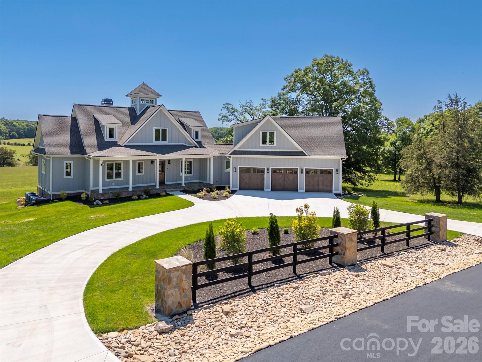 This brand-new luxury five-bedroom, 6.5-bath estate spans 10.10 gently sloping acres with panoramic mountain and pastoral views in the exclusive gated Mountain Meadows community. Designed for equestrian living and effortless indoor–outdoor flow, the 5,740 sq ft home offers exceptional versatility with both a full apartment over the garage and a fully self-contained lower-level suite—ideal for guests, multigenerational living, or long-term stays. There is a 3-car garage attached with wooden garage doors and epoxy flooring. The main level features 2,514 sq ft of thoughtfully crafted living space anchored by a vaulted great room with a floor-to-ceiling stone dual-fuel fireplace. Mornings begin with sweeping views from the east-facing covered porch, where the pastures come alive with light and wildlife. With gently rolling acreage, there is ample room for horses, a future riding arena, gardens, or simply the wide-open space that defines country living.The main-level primary suite includes two walk-in closets, a spa-inspired en-suite bath, and French doors to the porch. A second en-suite bedroom offers a comfortable space for guests or a private home office. The gourmet kitchen features a Thermador appliance package and a walk-in pantry, connecting seamlessly to the mudroom, powder room, and laundry for effortless everyday functionality. Upstairs, two additional bedrooms share a full bath, and the cupola brings natural light and architectural charm to the heart of the home.The lower level lives like its own residence, complete with a full kitchen, a bedroom with an en-suite bath, a walk-in closet, a flexible gym or hobby room, and an additional full bathroom. A second laundry room doubles as a safe room, complemented by abundant storage.Above the three-car garage, a private 639 sq ft one-bedroom apartment expands the property’s lifestyle possibilities—perfect for guests, income, or a dedicated work or studio space.Outdoors, the 10.10-acre setting enhances the home’s sense of retreat, with open grassland, professional landscaping with an irrigation system, a circular concrete driveway, a buried propane tank, fiber-optic internet, and a one-year comprehensive home warranty for peace of mind. The community offers nearly 2 miles of walking trails, and the FETA parking lot is just across the road, giving access to over 200 miles of riding trails. The development consists of only seven lots, and the road will be paved soon. All utilities are underground. Located just six minutes from shops, dining, and highway access—with quick routes to Hendersonville, Spartanburg/Greenville, and both GSP and CLT airports—this estate offers the rare combination of convenience and true country living.