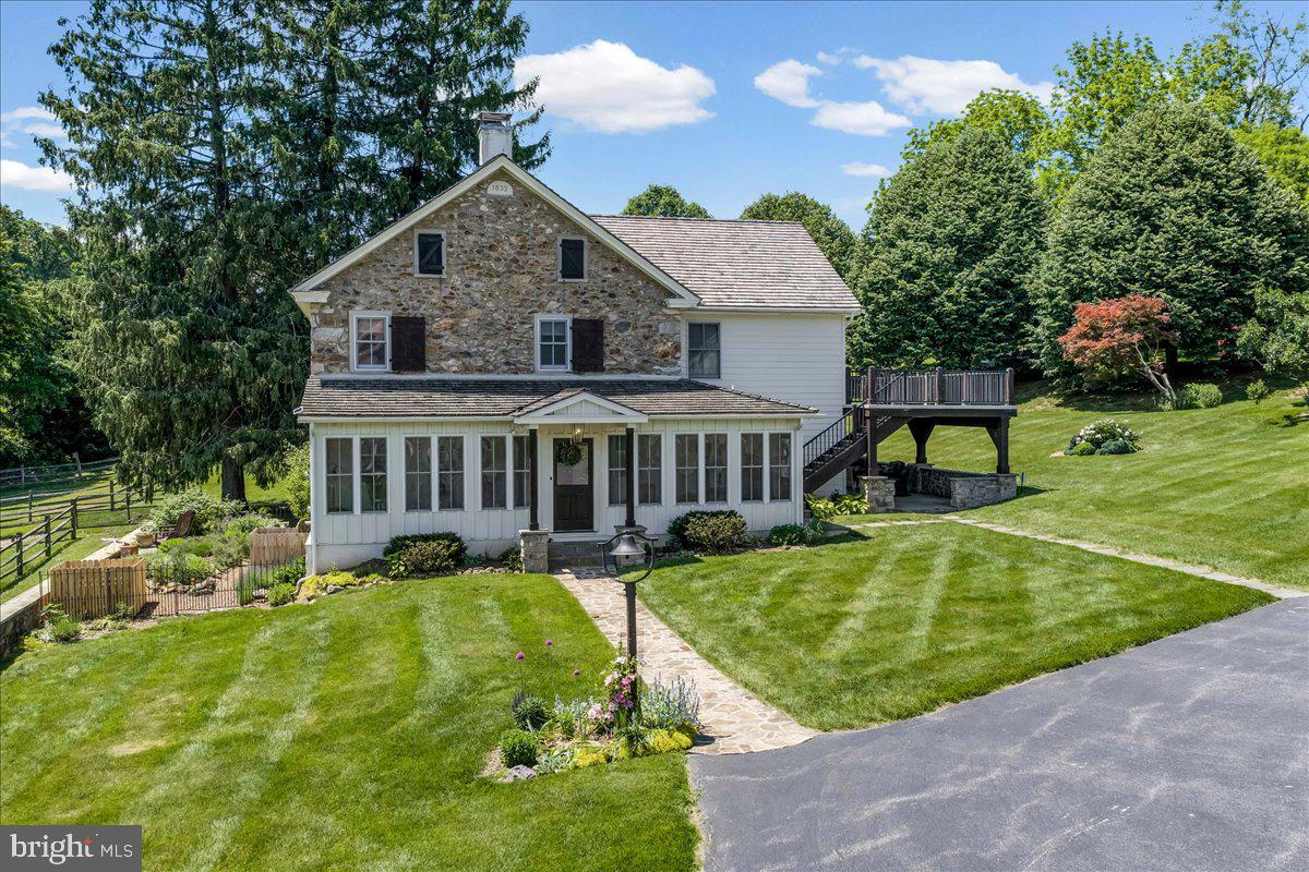 Look no further!  The breathtaking hard-to-find c. 1800 Three Kings Farm is nestled on a serene setting of 18.26 rolling acres, with a 36-tree fruit orchard, over 300 Christmas trees, and 6 fenced pastures.  Built by  three veterans of the War of 1812 and featured in the Chester County tour of historical homes, this Chester Springs beauty has it all, with its fabulous oversized stone bank barn with ample hay and equipment loft storage, 9 box stalls that conveniently lead to the animal paddock with large secure chicken coop, and a separate heated tack room.  A convenient well house offers shelter to the 18th century stone-lined well and keeps animal feed close at hand.  The second barn measures 24'x24', with an upstairs workroom and an attached oversized 3 car garage including washer, dryer, kitchen cabinets, and utility sink and a separate guest, caretaker and or in-law studio apartment with a full bath and wood pellet stove. A working stone spring house sits at the edge of the pasture and feeds the Pickering Creek.  The summer kitchen west of the main farmhouse offers outside entertaining opportunities near the slate covered patio and the south-facing herb garden.  As you travel to the home by the stone walkway you enter the main floor by the enclosed sun-filled front porch with high ceilings, wood floors and a spot for your rocking chairs.  You will delight in the flow to the Living Room with its wide plank wood floors and the home's original cooking fireplace as well as a corner fireplace with a stove insert, many recessed lights, curved plaster work and deep window sills offering majestic views.  The grandeur of the gourmet kitchen awaits with all its original historical heritage WOW factor and splendid modern-day amenities.  This chef and guest-friendly space is outfitted with period correct brick flooring, live-edge white oak island countertop, pendant lights and room for bar stools, 9 recessed lights, underneath cabinet ambiance lighting and an abundant supply of exquisite soft-touch cabinetry.  A built-in beverage refrigerator, Sharpe microwave, Thermadore stainless appliances, steam convection oven, and 6 burner Thermadore gas stove and oven make entertaining a joy.  Rounding out the main floor area is the Office with a gas-powered fireplace insert, hardwood flooring and rustic sliding barn door along with a Powder Room hall bathroom and the Laundry Room with sink off the kitchen for your convenience.  A quieter mood prevails upstairs.  The Primary Bedroom Suite is an airy sanctuary providing a peaceful place to unwind.  Situated for privacy and designed for comfort, this room features a doorway to the sizeable porch offering bucolic views, as well as wide plank hardwood flooring, recessed lights, walk-in closets, and a spa style bathroom for the ultimate escape, including large walk-in glass marble shower and flooring with recessed lights and double sink.  Three additional generous-sized bedrooms all with deep curved window sills and impeccable hardwood flooring with one that leads to the walk-up attic and another one with a pellet stove in the fireplace.  Additional upgrades,updates and features include: new roofs in past 5 years on all  the buildings,  recently installed $12,000 generator, heating and air conditioning systems updated in 2024, and added water treatment system, as well as reduced taxes through the Clean and Green program.  A turnkey farm with hens, goats, potbelly pigs, Icelandic sheep and two roosters can all be included.  This farm boasts the perfect location being close to the PA Turnpike, Septa R5 rail line with stops throughout the Main Line and Philadelphia, Great Valley Corporate Center, King of Prussia, shopping centers and stores.  Home comes complete with historic handwritten deed from 1863 and the original family's bible and German hymnbook as well as extensive research linking the farm to the original Penn land grants.  Come make this unique and one of a kind resale your new home today!