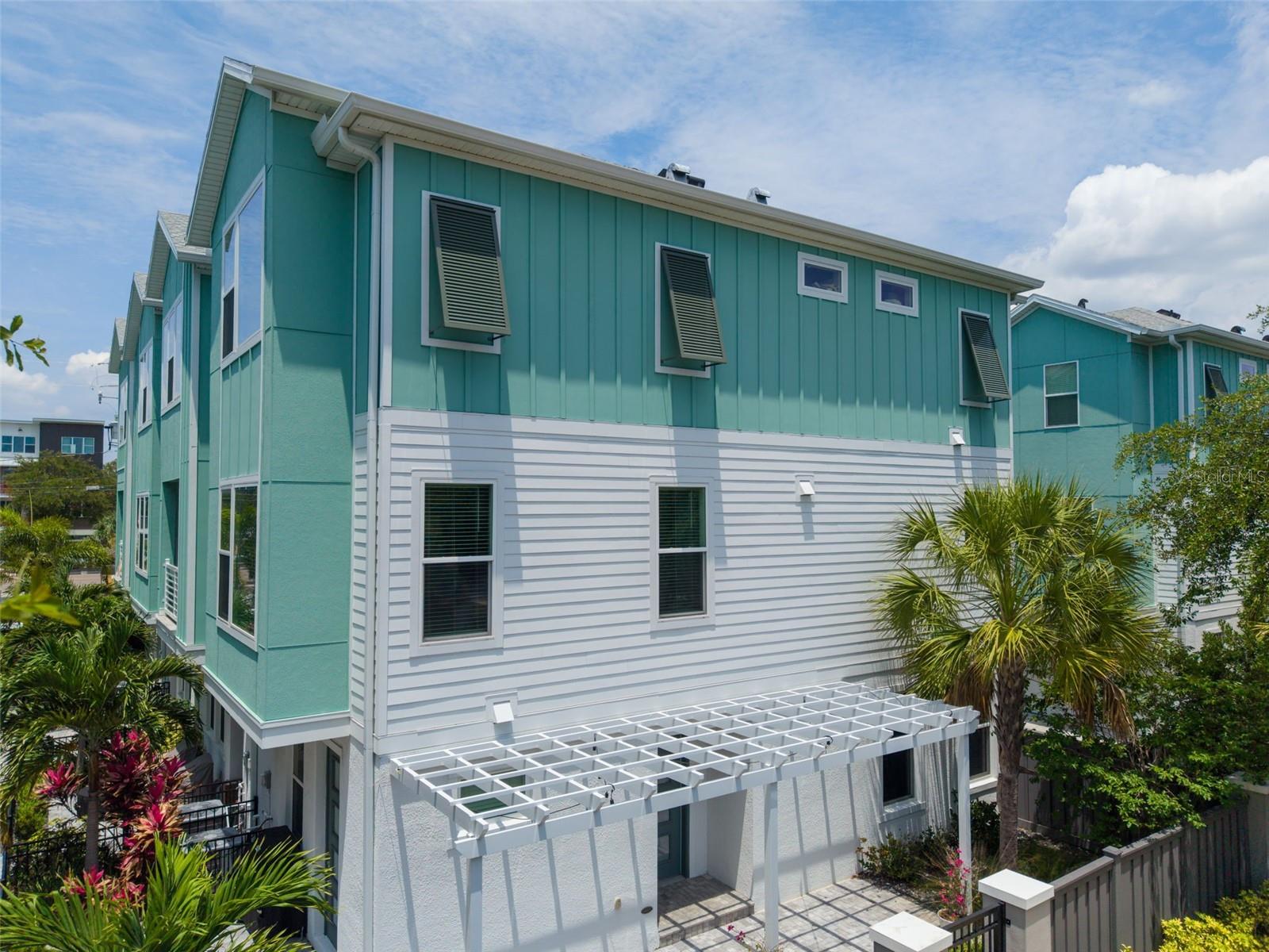 Located in the heart of the highly coveted Grand Central District and Historic Kenwood, two ofSt. Petersburg’s most vibrant and sought-after neighborhoods, this exceptional corner townhomeoffers a rare blend of modern luxury, architectural sophistication, and unmatched walkability.Just moments from acclaimed destinations including Baba, Urban Stillhouse, LALA St. Pete,The Listening Room, and Imagine Museum, residents enjoy effortless access to award-winningdining, nightlife, galleries, boutiques, and the renowned Second Saturday ArtWalk.Bathed in natural light from an abundance of impact-rated windows, this designer-curatedresidence showcases elevated finishes and timeless contemporary design throughout. Theexpansive open-concept living spaces are accented by soaring 10-foot ceilings, luxury vinylplank flooring across the first and second levels, and seamless indoor-outdoor flow designed forsophisticated entertaining.At the center of the home, the chef’s kitchen is both functional and striking, anchored by anoversized quartz waterfall island and complemented by crisp white shaker cabinetry, a gas rangewith convection oven, stainless steel appliances, custom dry bar with wine display and built-ins,and two spacious pantries including an oversized walk-in pantry off the dining area. Designerchandeliers and statement pendant lighting add warmth and refinement, while custom windowtreatments throughout the residence complete the polished aesthetic. Even the powder bath hasbeen thoughtfully elevated with dramatic mosaic tile detail.Each bedroom serves as a private retreat with its own en-suite bath and custom closet space,offering exceptional comfort and privacy for residents and guests alike. The luxurious primarysuite occupies the upper level and features elegant coffered ceilings, a spa-inspired bath, and animpressive custom California Closet system. A conveniently positioned laundry area on the thirdfloor enhances everyday livability.The first-level guest suite offers remarkable versatility with its own private entrance and directaccess to the home’s expansive wraparound patio. Framed by lush landscaping, a coveredpergola, and gated entry access, this outdoor living space creates an intimate and tranquil settingrarely found in urban living. Situated within a gated enclave, the residence also offers an addedsense of privacy and exclusivity.Additional highlights include a gas tankless water heater, abundant storage throughout, andthoughtfully selected luxury finishes that elevate every space. A truly exceptional offering in oneof downtown St. Pete’s most dynamic and culturally rich locations.