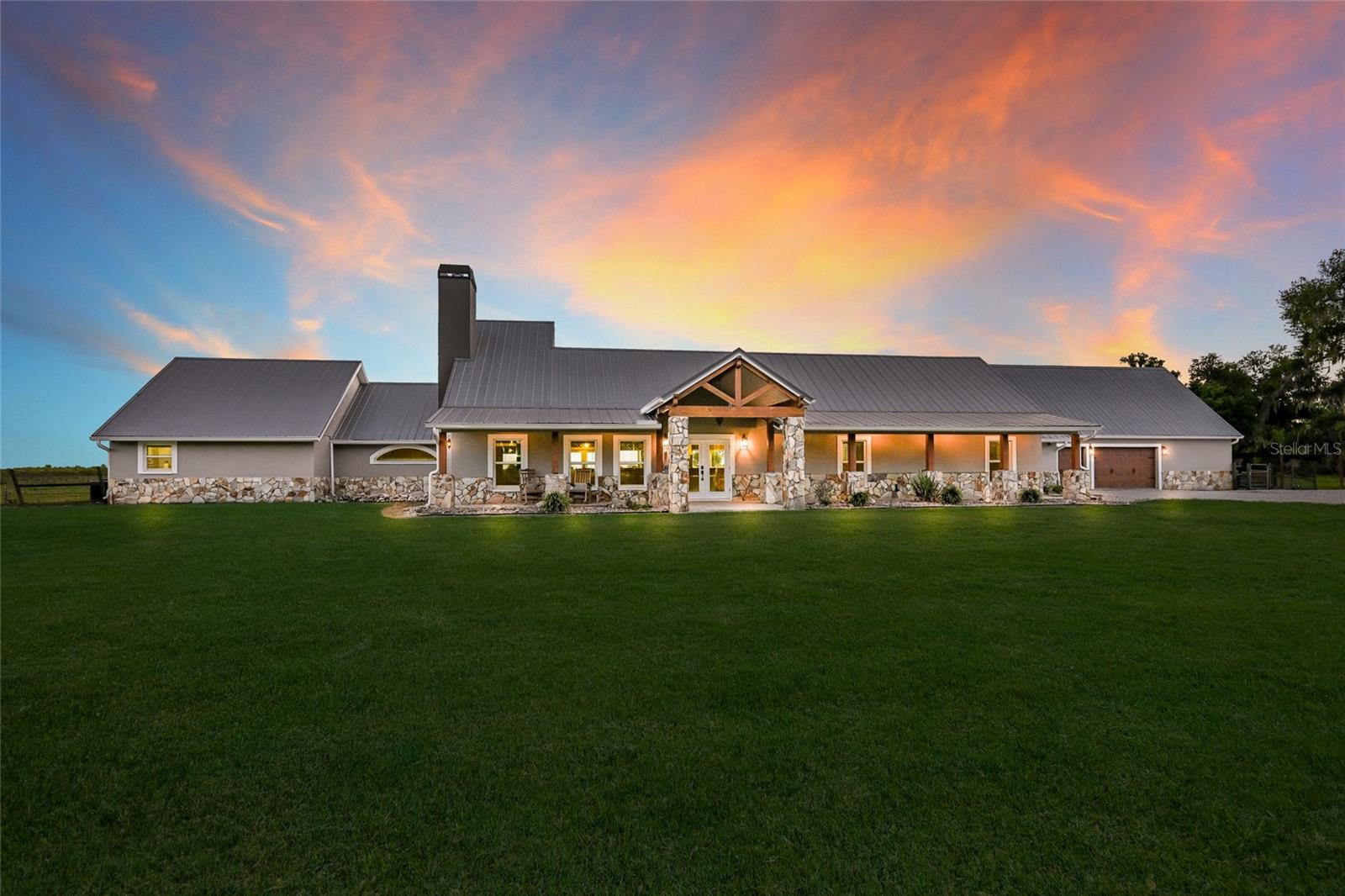 Welcome to an extraordinary private estate set on 80 pristine acres in the heart of Myakka City, just moments from the exclusive Soleta Golf Club. Framed by a grand canopy of mature oak trees, this custom-built residence offers a rare blend of refined luxury and serene countryside living. Spanning an impressive footprint, the home features five generously appointed bedrooms and six elegant bathrooms, thoughtfully designed for both elevated comfort and effortless entertaining. The primary suite serves as a true retreat, complete with a spa-inspired ensuite showcasing dual vanities, separate water closets, and expansive dual walk-in closets. A dedicated media lounge—ideal as a private theatre, game room, or fitness studio—enhances the home’s lifestyle appeal. Crafted with enduring block construction and crowned by a sophisticated metal roof, the residence exudes both timeless beauty and lasting quality. At the heart of the home, the gourmet kitchen is a chef’s showpiece, featuring granite surfaces, an oversized island with dual sinks, a farmhouse apron sink, and a professional-grade six-burner Wolf gas range with griddle and hood. The open-concept design flows seamlessly into the dining and living spaces, where engineered hardwood floors and a gas fireplace with designer tile surround create an inviting yet upscale ambiance. Outdoors, a resort-style oasis awaits. The striking 50' x 24' custom pool is perfectly positioned to capture sweeping views of the surrounding landscape and is complemented by integrated outdoor audio and a gas connection for al fresco entertaining. Beyond, the estate reveals a picturesque four-acre pond and a private 300-yard shooting range, offering a unique blend of recreation and tranquility. Designed with versatility in mind, each bedroom enjoys its own ensuite bath and ceiling fan for ultimate privacy. The property also includes a private interior studio apartment, as well as a full guest residence above the garage—complete with its own kitchen, living area, and a newly upgraded Trex deck overlooking the pool. With no deed restrictions or HOA, this exceptional property offers complete freedom to embrace a luxury rural lifestyle, whether accommodating livestock or simply enjoying the expansive grounds. A gated entrance ensures both privacy and security, while convenient access to Interstate 75 and Lakewood Ranch places world-class amenities within easy reach. This is more than a home—it’s a legacy estate where elegance, space, and lifestyle converge.