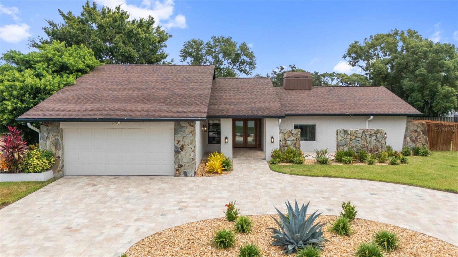 STOP THE CAR!!!!  NO FLOOD INSURANCE REQUIRED!!  ZONED PALM HARBOR UNIVERSITY HIGH SCHOOL. Gorgeous, BLOCK CONSTRUCTION, 4 Bedroom, 2 Bathroom, 2 Car Garage, POOL HOME located in the very desirable Palm Harbor neighborhood of "Eniswood". Pride of Ownership is obvious as you pull up to this BEAUTIFULLY LANDSCAPED property with NEWER PAVERED, CIRCULAR DRIVEWAY (2023).  Enter through the DOUBLE DOOR ENTRY and be prepared to be wowed!! This home has so many features including... NEWER ROOF 2020, ENTIRE EXTERIOR PAINTED (2025) WITH NEW GUTTERS! (2025), UPDATED AIR CONDITIONING PRIMARY SIDE 2023, NEWER VINYL FLOORING 2022, GRANITE KITCHEN with WOOD CABINETS and STAINLESS STEEL APPLIANCES; SPLIT BEDROOM FLOOR PLAN; UPDATED SECOND BATHROOM with DOUBLE VANITY; SPACIOUS PRIMARY SUITE with LARGE WALK-IN CLOSET, BATHROOM with DOUBLE VANITY and sliding doors to the pool area; Large FAMILY ROOM with DOUBLE SIDED FIREPLACE and VAULTED CEILINGS, INTERIOR LAUNDRY/UTILITY ROOM, OVERSIZED 2-CAR GARAGE, WITH NEW OPENER (2025), SCREEN-ENCLOSED IN-GROUND RESURFACED POOL (2019) and a HUGE FENCED IN BACK and SIDE YARD (2023) with 1,365 SF of NEW OUTSIDE TURF (2024) along with a NEW IRRIGATION SYSTEM (2023) for the entire family!! ENERGY EFFICIENCY UPGRADE WITH BLOWN-IN INSULATION THROUGH THE ENTIRE HOUSE (2024)! Located at a HIGH ELEVATION, this home is NON-FLOOD and zoned for Palm Harbor High School. Close to restaurants, shops, hospital and a short commute to the Bay Area beaches and two International Airports, this home is a MUST SEE!!!