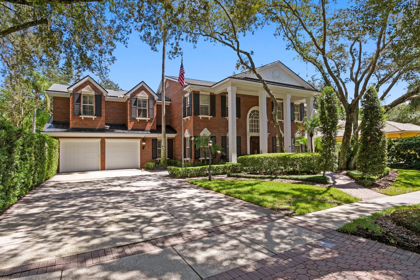 Welcome to this gracious residence in Tampa Palms, where timeless architecture meets an unexpectedly enchanting retreat. Set beneath a canopy of mature oaks on a quiet cul-de-sac, this enduring custom built home offers .58 acres of lush gardens and elevated modern living. With a grand 27-foot entry foyer, inlaid flooring, modern accent moldings, a well-appointed kitchen and a discerning wine room, this home artfully bridges refined heritage and modern luxury. Inside, warm wood floors, richly crafted architectural details and generous living spaces create an inviting sense of elegance. The updated kitchen opens to a central gathering area and flows easily to an expansive covered lanai with fireplace, overlooking the large, heated saltwater pool and gracious grounds. Beautifully proportioned living spaces, including a private office, clubroom, game room and sauna, offer plentiful spaces to live, work and unwind. Outside, discover what sets this property apart. Winding garden paths meander through this remarkable backyard, abundant with mature landscaping, quiet sitting areas and delightful surprises at every turn. Pause beside the koi pond, gather beneath the gazebo or escape to the charming treehouse tucked among the oaks. There is a large and enviable outdoor dining area with hearth, ideal for entertaining under the stars. This grand home offers indoor-outdoor living designed for everyday comfort and elevated modern living. Make Tampa Palms easy lifestyle and this lovely property your own. Minutes to the clubhouse for golf or tennis. Conservation lot, cul-de-sac, EV charger, Wolfe, underground utilities and low HOA fees. Near USF and Moffitt, parks, beaches and sports venues. Video available of this beautiful home and grounds.