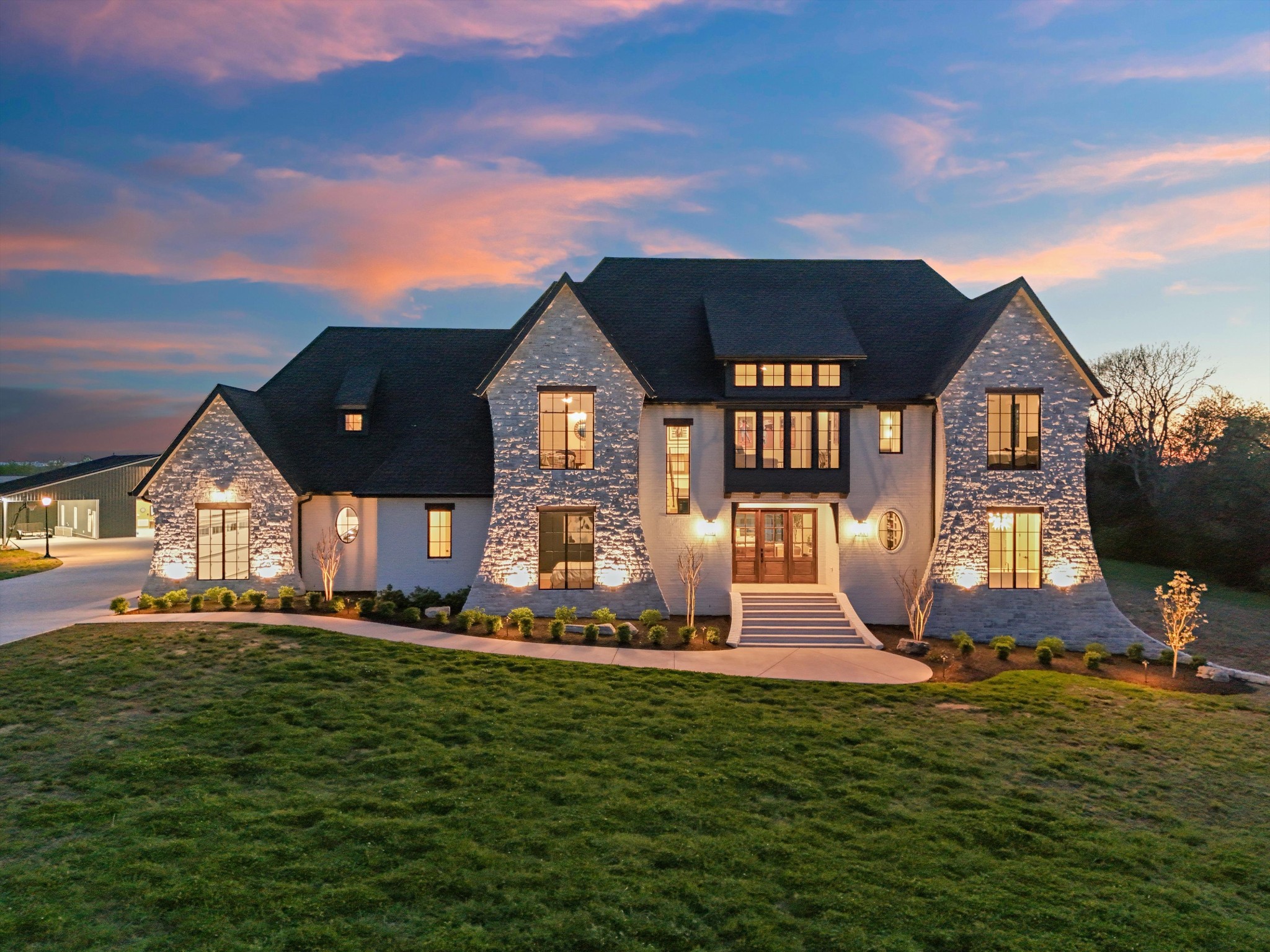 Extraordinary private estate on 15.5 serene acres featuring a rare 100’x80’ indoor training facility, a 30’x50’ conditioned workshop with full bath, and a high-efficiency luxury home with 5 attached garage spaces - all conveniently located near Nashville, BNA, I-40, and Providence.Designed for both everyday living and entertaining, the home offers an open floorplan with high-end finishes throughout, a chef’s kitchen with Fischer & Paykel appliances, dual dishwashers, commercial-grade refrigerator/freezer, and a stunning main-level primary suite with heated tile floors and custom walk-in closet.The basement is built for entertaining with 10’5” ceilings, theater room, game room, workout space, kitchen area, full bath, and storm shelter with 10” concrete walls.Outside, enjoy a true resort-style setting complete with outdoor kitchen and bath, covered patio, stone fireplace, firepit area, gunite saltwater sports pool, hot tub, tanning ledge, and sweeping sky views from sunrise to sunset.Additional highlights include custom offices with built-ins, six WiFi access points, second laundry room, over 1,000 sq ft of unfinished expansion space, and two additional approved 4-bedroom perc sites for future building opportunities