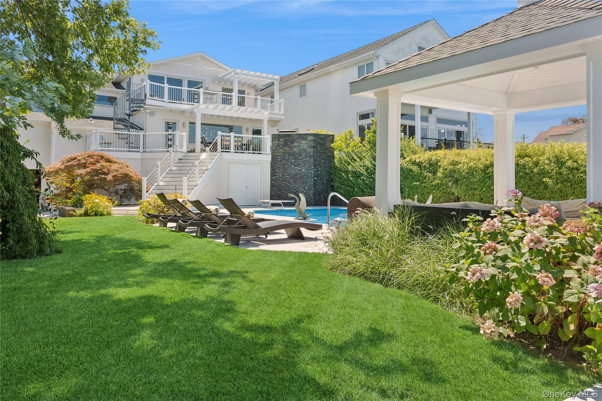 Contemporary Coastal Bayfront Retreat over-looking bird sanctuary.  Personal Marina. 2 boat lifts. One in-water slip. Jet-ski lift. One davit. Floating Dock.  Swimming Pool 8 ft deep end diving board. Hot tub with waterfall overflow. Gazebo. Custom fire pit. Outdoor/Indoor Sonos Sound System.  Pergola Dining Deck with open air Kitchen flows indoors to custom built gourmet kitchen featuring high end appliances. Double oven + warming drawer. Pot filler. Granite Island barstool seating flows into dining room and living room for seamless entertaining.  Billiard room. Built in bar. Office area. Juliet balcony. Primary Suite private deck with Pergola. Four Levels of Luxury Living space with dedicated bedroom and bath on each level.  Elevator. Three car garage with pass through for easy water access.  Epoxy flooring. Workshop. Above ground basement for plenty of storage space.  FEMA Compliant.