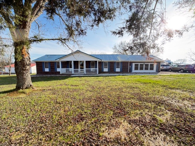Escape to peaceful country living in this charming 2bdr/2bath brick home set on nearly an acre of scenic land. Inside, you'll find beautifully updated LVP flooring flowing throughout a warm inviting layout, designed for both comfort and easy upkeep. Outside the property continues to impress with a spacious detached shop perfect for hobbies, equipment, or extra parking-as well as a generous storage building to keep everything organized. Tongue and groove ceiling in the den and a cedar back covered patio.  The home was a 3 bedroom, but one bedroom has been converted to a large bath and laundry. Plenty of room to make a 3rd bedroom if needed.