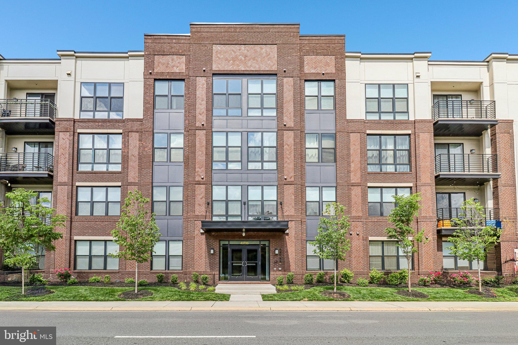 Exceptional one-level condo offering 1,804 square feet of elegant, contemporary living. From the moment you enter, you’ll fall in love with the expansive sun-filled living and dining room combination featuring hardwood floors, a fireplace, and a wall of windows with access to a private balcony overlooking the community green.  The gourmet kitchen is perfect for entertaining and showcases top-of-the-line upgrades throughout, including a large island that enhances the spectacular modern design.  The spacious primary suite, located on the left side of the home, features windows on two sides, a walk-in closet, and a luxurious primary bath with a stunning oversized shower and double vanities.  The large secondary bedroom on the opposite side of the residence is equally impressive, offering excellent privacy and space. A separate den provides the perfect flex space for a home office or additional sitting area. Separate storage just off the hall is an added bonus.  This secure building with an elegant lobby is a rare find. Exceptional location near shopping, dining, and approximately one mile to the Metro.