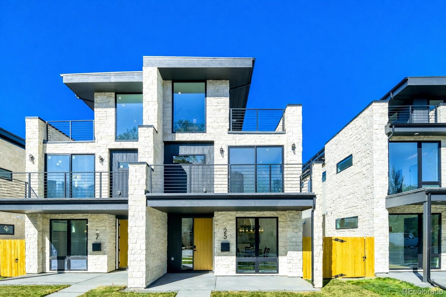 A statement in modern design, this architecturally curated Cherry Creek duplex reflects PBG’s uncompromising attention to detail and craftsmanship. Less than a 10 minute walk from the neighborhood’s premier dining/boutiques, the 5-bed, 5-bath residence blends organic textures with elevated, contemporary interiors. Natural stone and warm wood accents are framed by clean architectural lines, forming a timeless, design-forward exterior. Inside, wide-plank engineered white oak flooring and expansive glazing invite abundant natural light, defining the home’s bright interior. The living room is anchored by a sculptural fireplace framed by refined wall detailing, creating a clean and sophisticated focal point. Designed as the heart of the home, the chef’s kitchen showcases custom two-tone cabinetry in satin white oak and soft white, accented by brushed nickel hardware, integrated Thermador appliances, and a statement waterfall island clad in Matarazzo leathered stone. Upstairs, the primary suite features a private balcony, gas fireplace, and wet bar, complemented by a spa-caliber bath finished in Matarazzo leathered stone and blonde ash KRO cabinetry. The bathroom showcases accent tile, dual wall-mounted champagne bronze faucets, a freestanding soaking tub, a glass-enclosed dual-head shower, and heated floors. A secondary en-suite bedroom and spacious laundry room complete this level. The rooftop level offers a bedroom and office, ¾ bath, wet bar, and expansive deck with city views and mountain views. The finished basement with soaring 10-foot ceilings expands the home with a recreation area, wet bar, full bath, additional bedroom, and optional fitness room. A private backyard with covered patio, gas hookup, and TV prewire extends the indoor/outdoor lifestyle. Detached two-car garage includes 220V capability and optional overhead storage. PBG industry leading 2-year builder’s warranty/8-year structural warranty. Prewired for speakers | No HOA | |Buyer to Verify All Details