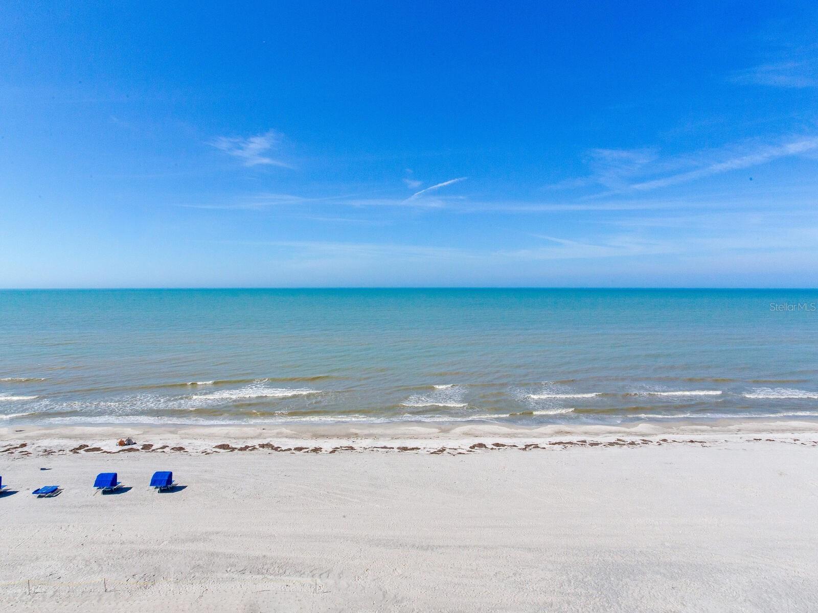 7TH FLOOR CORNER UNIT | UNOBSTRUCTED GULF VIEWS | DIRECT BEACHFRONT | TURN-KEY Experience coastal living in the heart of beautiful Indian Shores. Perfectly positioned directly on the sugar-white sands of the Gulf, this exceptional 2-bedroom, 2-bath corner residence offers expansive, unobstructed water views that truly set it apart. Situated on the 7th floor, this unit clears the neighboring building, providing wide-open panoramas and breathtaking sunsets that stretch for miles and from the front of the unit you get intracoastal views. Natural light pours into the spacious interior, enhancing the bright coastal ambiance and creating a seamless connection between indoor comfort and the stunning Gulf backdrop. The open living areas flow effortlessly to the Gulf-front balcony, an ideal space to relax, entertain, and soak in the view. A private storage closet on the balcony provides convenient space for beach chairs and seasonal items. Offered FURNISHED and truly TURN-KEY, this residence allows for immediate enjoyment or rental income from day one. Residents enjoy elevator access and a laundry room on each floor with newer washers and dryers. The community amenities are exceptional, featuring a large Gulf-front sun deck and a heated and cooled beachfront pool for year-round enjoyment. This well-maintained, FULLY FUNDED, PET FRIENDLY building offers NEWER ROOF and ELEVATORS, a BUILDING GENERATOR, and MILESTONE INSPECTION HAS BEEN COMPLETED, providing added confidence and assurance in the structural integrity and safety of the property. The inviting common areas include a community room with pool table, full kitchen, cozy library, and dedicated bike storage. Owners also enjoy access to a PRIVATE GUEST CONDO within the building that can be rented at a nominal cost, an incredible benefit for hosting friends and family. Investment flexibility is strong with 30-day minimum rentals permitted. The association benefits from multiple income streams, including rooftop AT&T equipment revenue, contributing to one of the most financially solid communities on the beach. One assigned parking space (#701) is included.  The location is unbeatable—walk to local restaurants, cafés, pubs, beach rentals, putt-putt golf, and the trolley stop. Just minutes to Clearwater Beach, St. Pete Beach, Seminole City Center, and John’s Pass Village, with Tampa International Airport approximately 30 minutes away.  Whether you’re seeking a primary beachfront residence, seasonal retreat, or income-producing investment, this 7th-floor Gulf-front opportunity delivers unobstructed views, strong financial fundamentals, and an unbeatable coastal lifestyle.