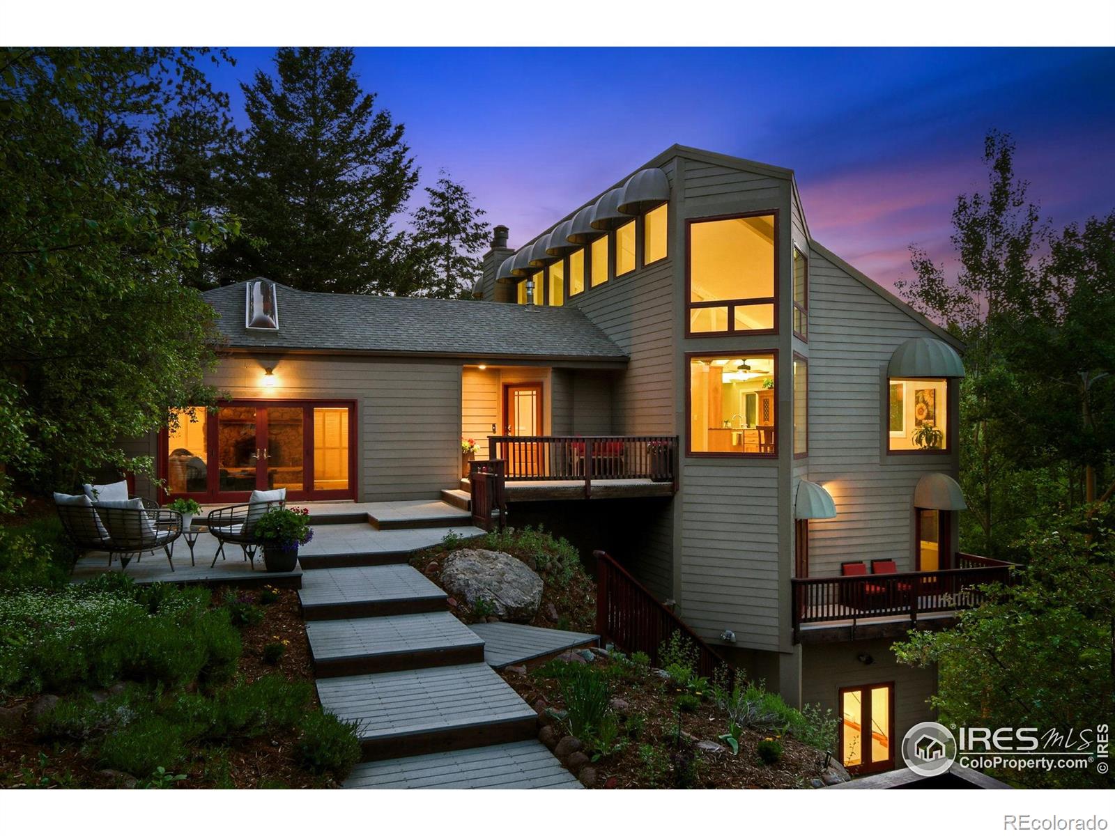 Discover the rarest of combinations in Boulder: a private compound with an art studio and a detached guest house featuring panoramic views all just 5 miles from the Pearl Street Mall. Welcome to this Pine Brook Hills sanctuary where luxury meets inspiration. At the heart of this nearly 1-acre estate is a beautifully remodeled main residence, a sun-drenched haven filled with vaulted ceilings, skylights, and panoramic foothill vistas from every window. The open-concept design features a spacious great room, a modern chef's kitchen, and two generous living areas. The primary suite feels like a secluded treehouse escape and includes direct deck access. What truly elevates this property are two distinct bonus spaces: a sprawling 800sf studio with a private entrance-perfect for an artist, home gym, or expansive office - and a charming 500sf guest house above the garage, ideal for visitors, remote work, or a private retreat. Step outside to enjoy over 1,000sf of Trex decking, seamlessly connecting you to the serene landscape & remarkably flat, fenced yard space-a true mountain rarity. Enjoy ultimate peace of mind with a brand new Class 4 impact-resistant Owens Corning STORM roof, which includes a transferable warranty & may qualify for significant homeowner insurance discounts. This mountain lifestyle is made effortless with paved roads, natural gas, community water, a voluntary HOA, a neighborhood fire station, & reliable school bus service. With nearly 5,000sf of finished space under roof, this property delivers the perfect blend of creative freedom, privacy, and convenient access to town. For the artist, entrepreneur, or anyone seeking an inspired haven, your search ends here.