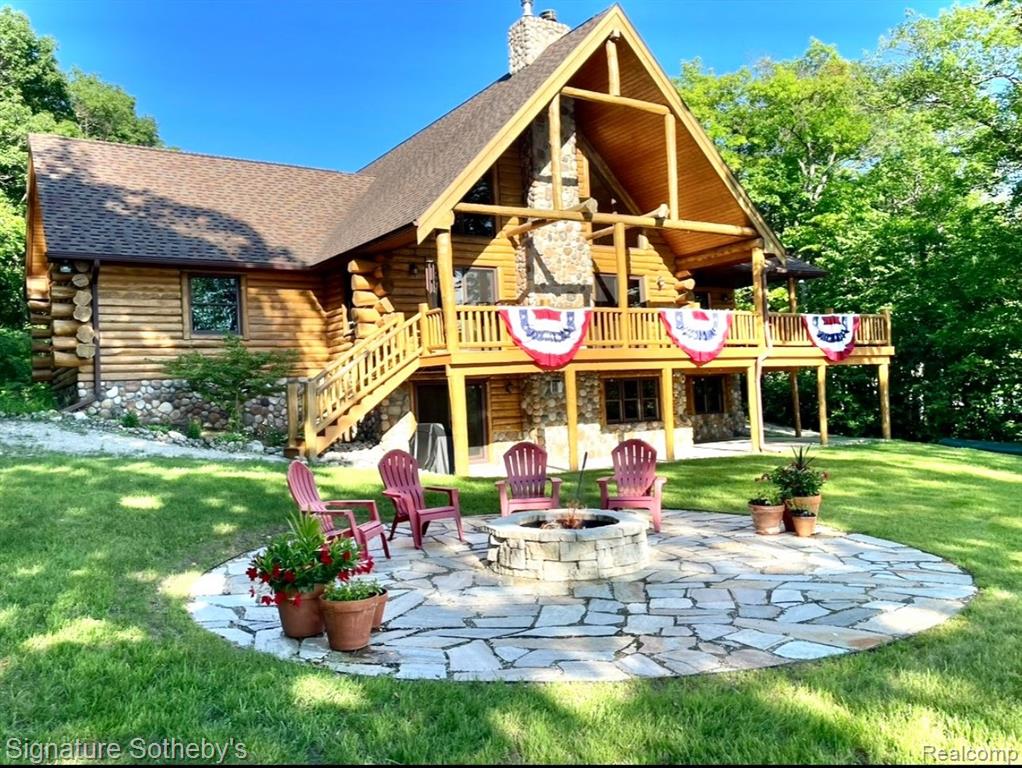 A grand welcome-meet craftsmanship where every detail tells a story and where lakeside living is elevated to an art form.  As you wind down the 975 ft paved tree lined driveway, the vision unfolds of a one-of-a-kind log custom built  masterpiece.  It's rich Michigan-Native timber milled onsite with a detached 2 story 3-car garage, with plenty of storage for your vehicles, equipment and lake-life essentials . Upon entering a kitchen, worthy of a chef, with new custom cherry kitchen, granite countertops, massive center island and dual sided storage.  Including built in Microwave drawer, French door SS Refrig., wine refrig.,48" SS Wolf range, double ovens, griddle, grill  and Zephyr range hood.  A 2-story Great room with floor to ceiling stone gas fireplace. The wraparound deck offers breathtaking lake views from Great room with oversized door walls and windows.  Complete with vaulted ceiling in dining room.  Primary bedroom on first level with spa like ensuite bath  featuring oversized custom shower, cherry double vanity & Kohler fixtures.  Second level offers bright loft bedroom, hardwood floors, double closets, w/updated full bath.  Lower level fully refinished walk-out offers full kitchen, third bedroom in lower level w/fully updated new bath.  Additional large family room with custom wood beams w/floor to ceiling stone fireplace for entertaining. Also included large storage room.  Step outside this beautiful home and look upon 178 ft. of beautiful shoreline of all sports Grand Lake.  Seller is offering a new roll-in L shaped dock w/oversized sundeck.  Boat lift and snowmobile access offers all four seasons of enjoyment!  Custom 18ft. circular fieldstone patio and firepit .  New HVAC water softener, sump pump, updated electrical panels, and whole house Generac 24KW generator.  Nothing left to do but turn the key, step inside and let Pure Michigan life begin!!  All buyers to provide proof of funds. Min. 48 hrs. to show - listing agent must be present at all showings.  BATVAI