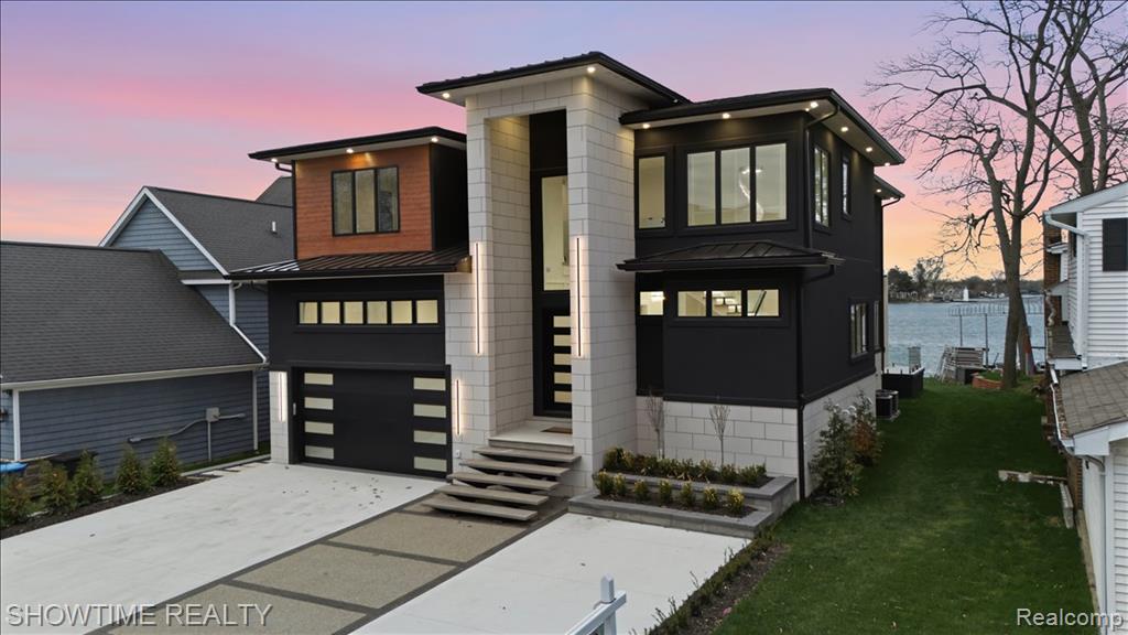 Experience a rare chance to own a brand-new luxury build on all-sports Lake Fenton — Sodded with a sprinkler system and a 5' Crawl space, crafted from the ground up with top-tier finishes. This isn’t your typical new construction; every detail was designed to stand out. As the tallest home on the street, it makes an immediate impression with a custom driveway and limestone entry steps. Inside, the foyer sets the tone with a soaring ceiling and double chandeliers. A custom wine display greets you before the office, and as we enter the living room, a massive Montego porcelain-slab fireplace centers the space while pulling you toward the covered lakeside patio. The kitchen offers a coffee bar, wine bar, Cristallo countertops, and a full Lighted Cristallo island paired with top-tier appliances. A second kitchen with a double convection oven keeps daily cooking simple. The garage was built for car lovers — designed to support a lift holding two additional cars for up to four total, and finished with fresh epoxy and added traction flakes.Upstairs, custom-lit stairs lead to four bedrooms, each with walk-in closets and private full baths. Convenience continues with two laundry rooms — one on the main floor and one upstairs. Two bedrooms, including the primary suite, overlook the lake, and the primary features a walk-out balcony perfect for morning coffee or peaceful summer nights. The primary bathroom and walk-in closet feel like a true retreat, crafted with stunning finishes and the kind of elevated detail that sets this home apart the moment you see it.Opportunities like this almost never hit Lake Fenton — true new construction, modern design, and craftsmanship that’s becoming harder to find each year. This home delivers a level of luxury, quality, and presence that buyers wait a while for. If you’ve been looking for something exceptional, something that genuinely stands out from everything else on the lake, this is your moment. Schedule your private showing today
